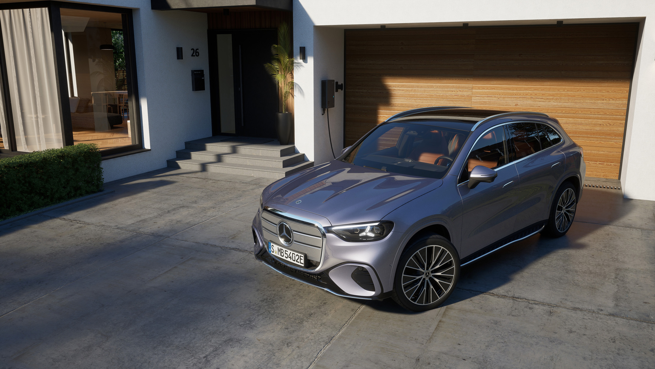 Zu Hause Laden | Mercedes-Benz Ein neuer, elektrischer GLB in Lavendersilber steht vor einem hölzernen Garagentor.