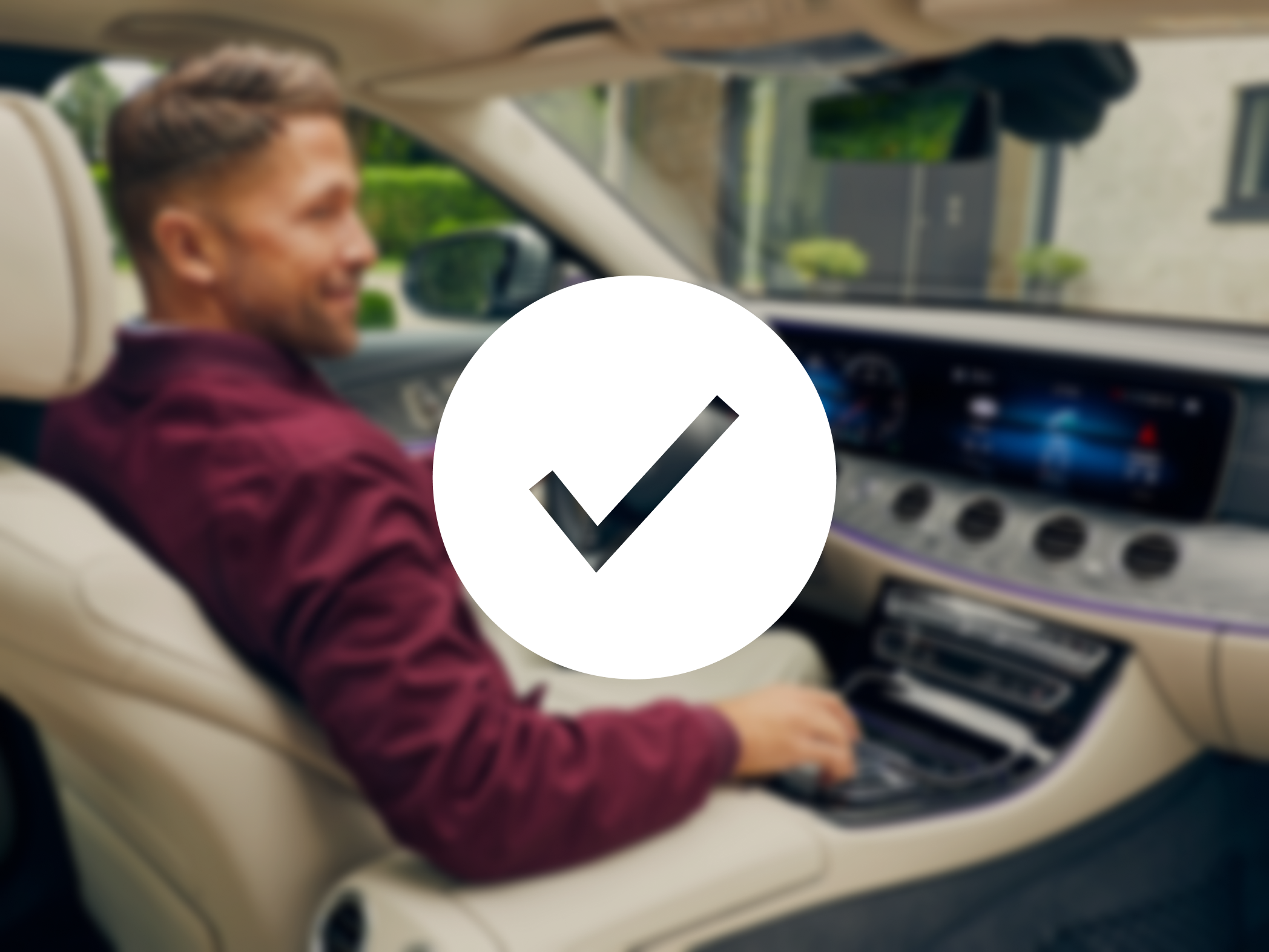 Ein Mann sitzt am Steuer eines Mercedes-Benz.