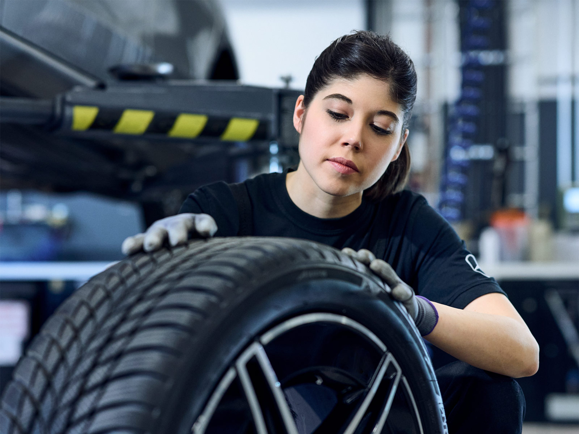 Herbstaktion | Mercedes-Benz Mercedes-Benz Mechanikerin mit Handschuhen an beim Prüfen der Reifenprofiltiefe.