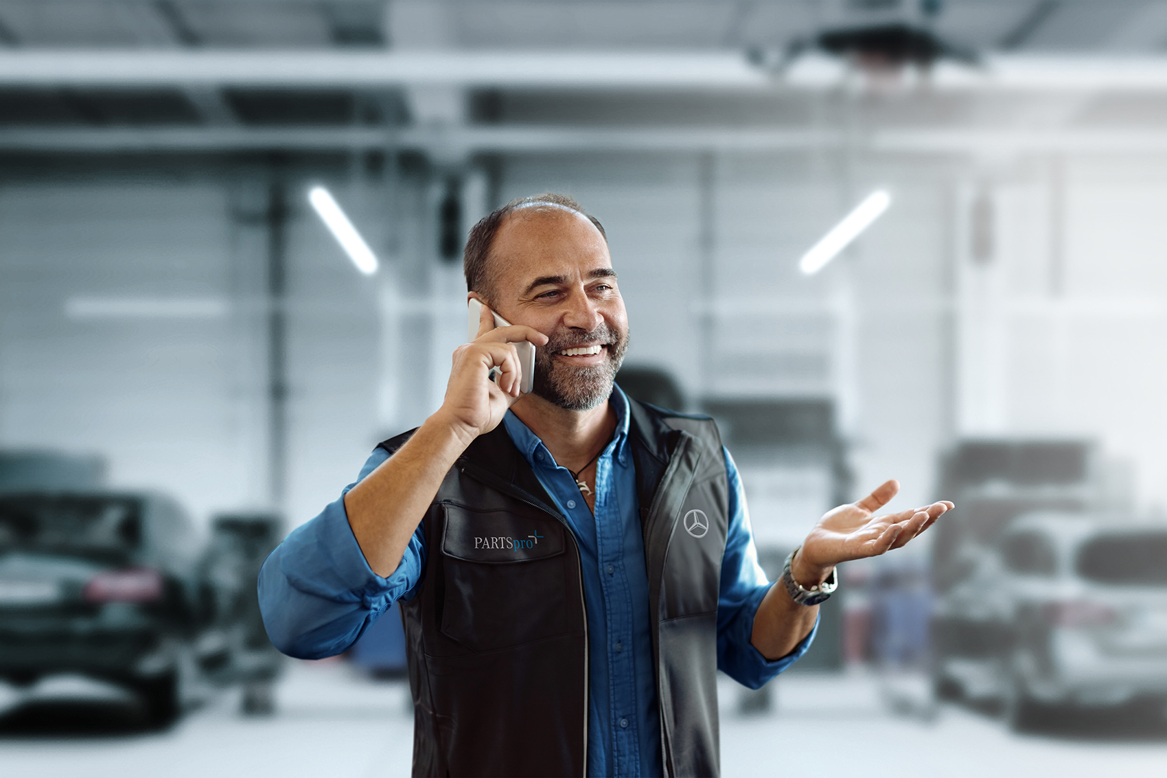 PARTSpro+ | Mercedes-Benz. Ein Mann lächelt beim Telefonieren.