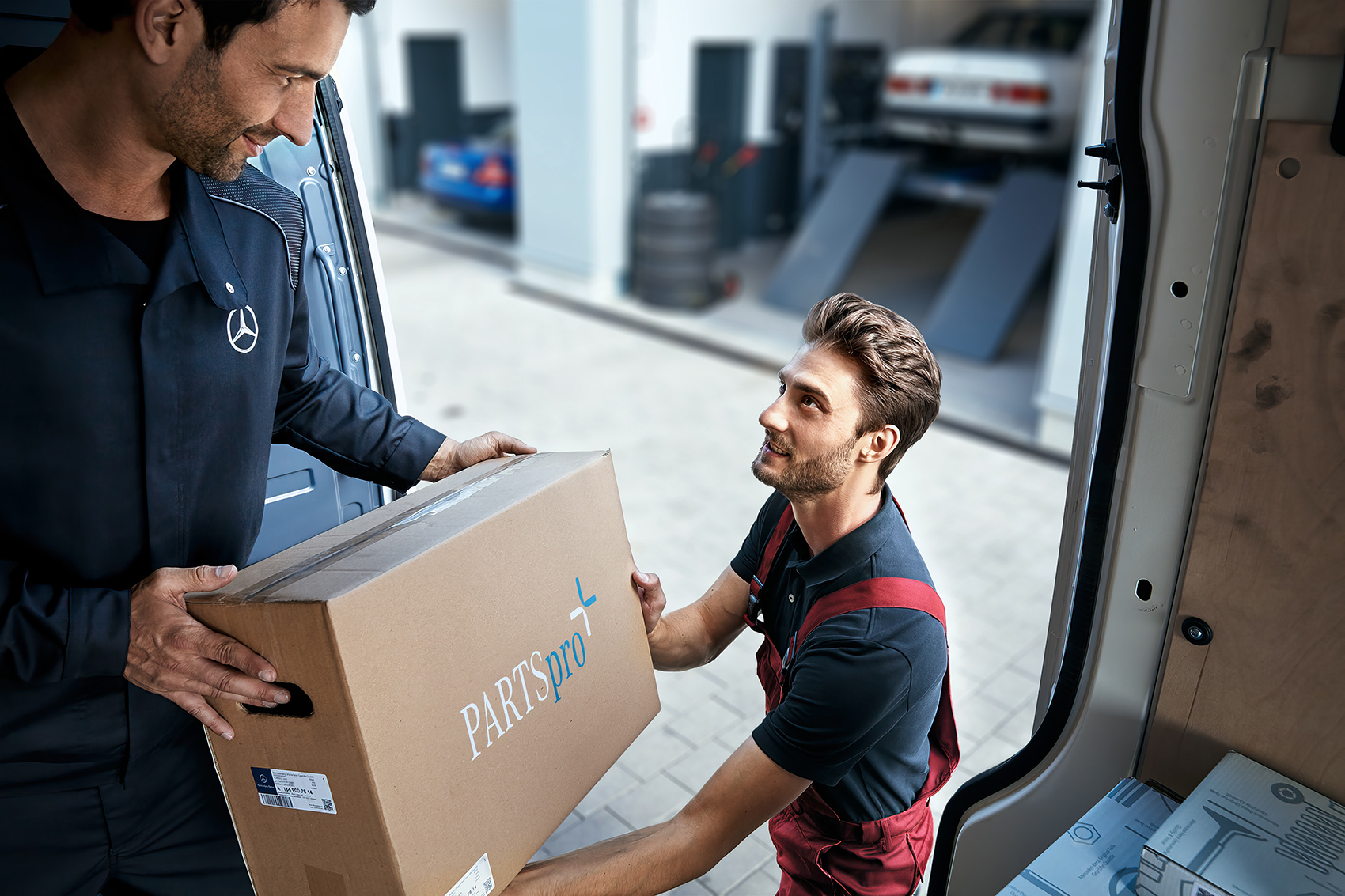 PARTSpro+ | Mercedes-Benz. Ein Mann übergibt ein Paket.