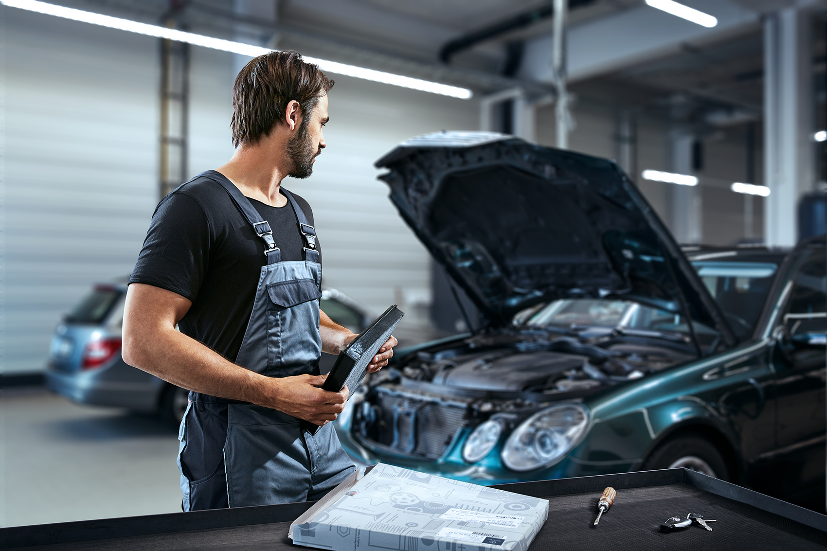 PARTSpro+ | Mercedes-Benz. Ein Mann arbeitet an einer geöffneten Motorhaube.