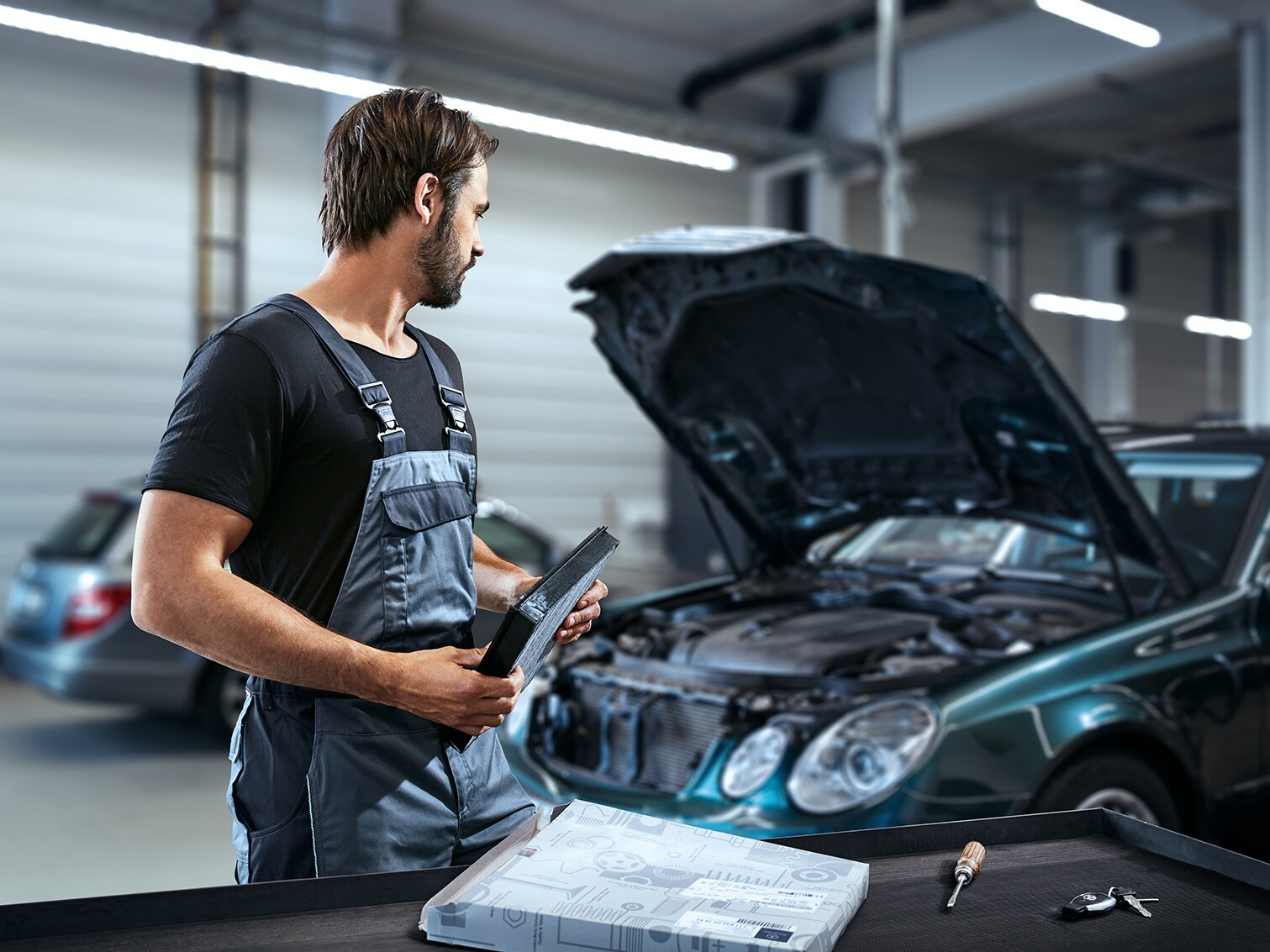 Ein Mann arbeitet an einer geöffneten Motorhaube.
