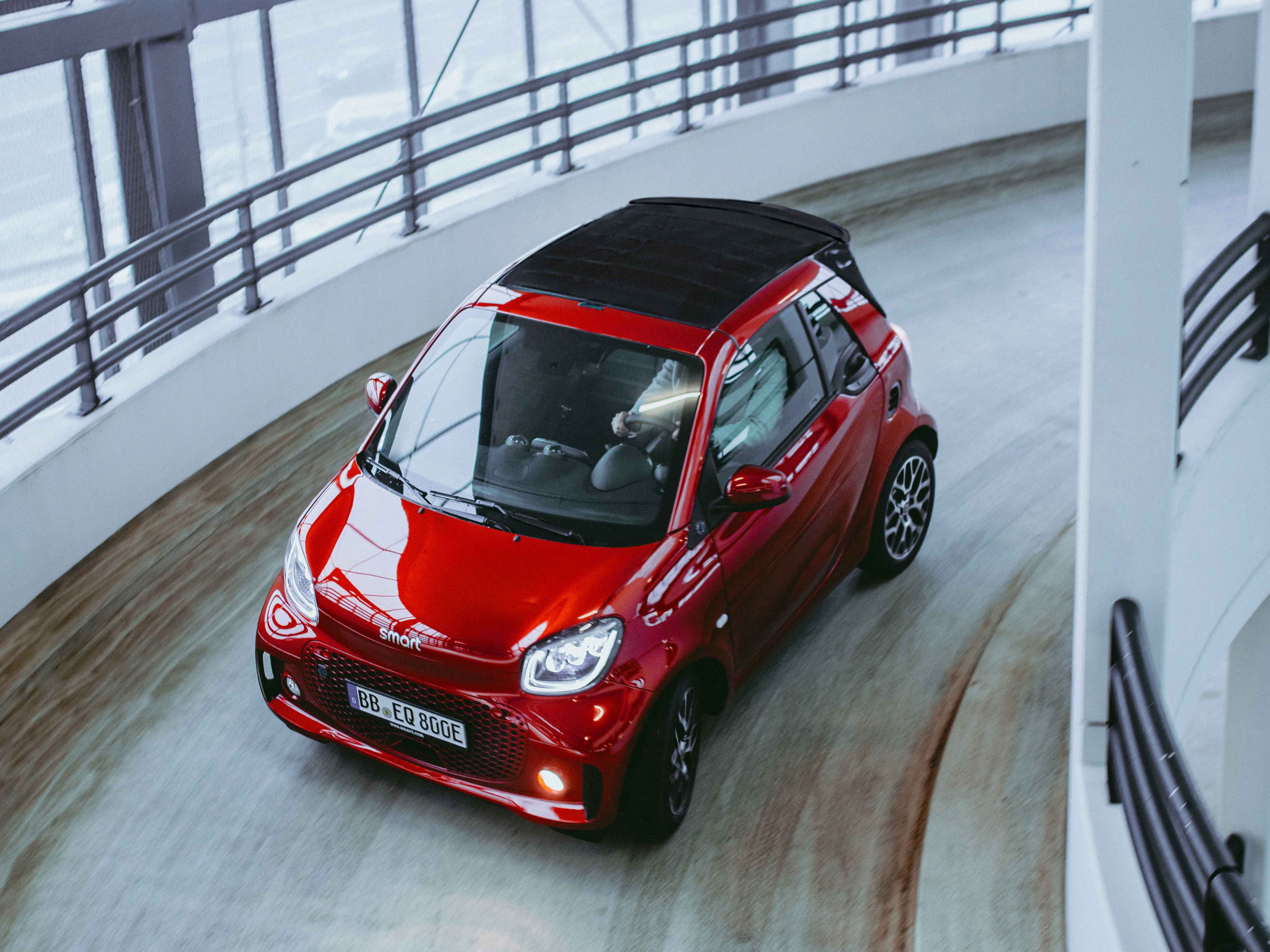 Ein roter smart fortwo fährt in einem Parkhaus hoch.