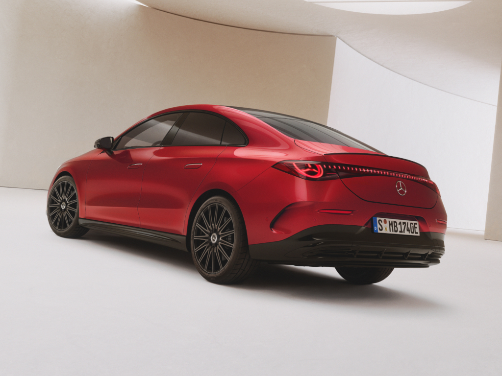 Elektroauto Förderungen | Mercedes-Benz. Seiliche Rückansicht eines roten vollelektrischer Mercedes-Benz CLA, der in einer hellen lichtdurchfluteten Halle steht.