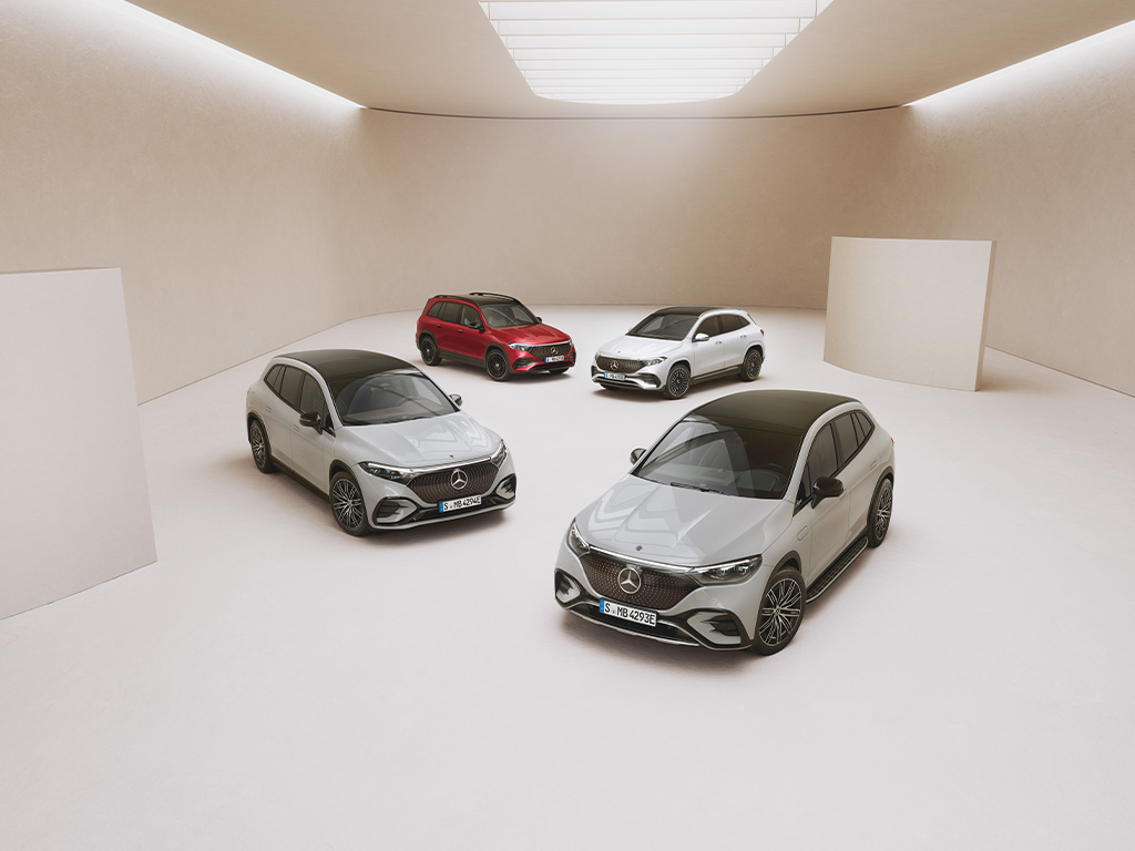 Elektroauto Förderungen | Mercedes-Benz. Vier vollelektrische Elektrofahrzeuge von Mercedes-Benz stehen auf hellem Untergrund in einer lichtdurchflutenden Halle.