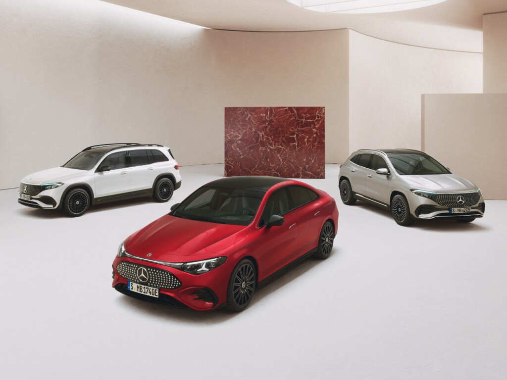 Drei vollelektrische Elektrofahrzeuge von Mercedes-Benz stehen auf hellem Untergrund in einer lichtdurchflutenden Halle.