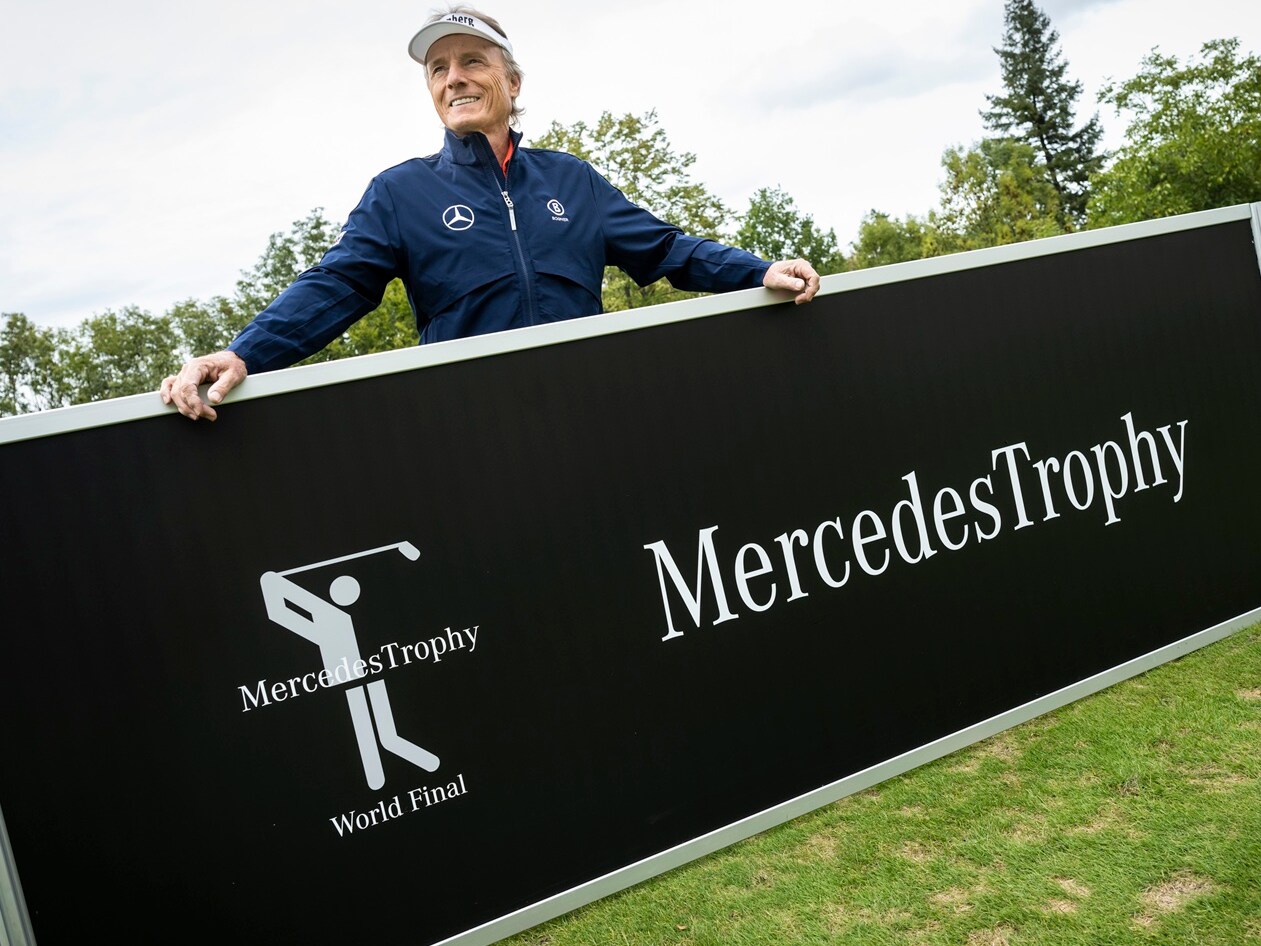 Ein Mann hält einen Werbebanner mit der Aufschrift "MercedesTrophy".