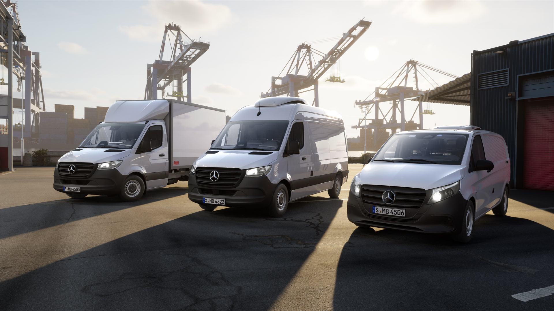 Auf- und Umbaulösungen | Mercedes-Benz Transporter. Drei Mercedes-Benz Transporter stehen auf einem Containerterminal vor Hafenkränen im Logistikumfeld.