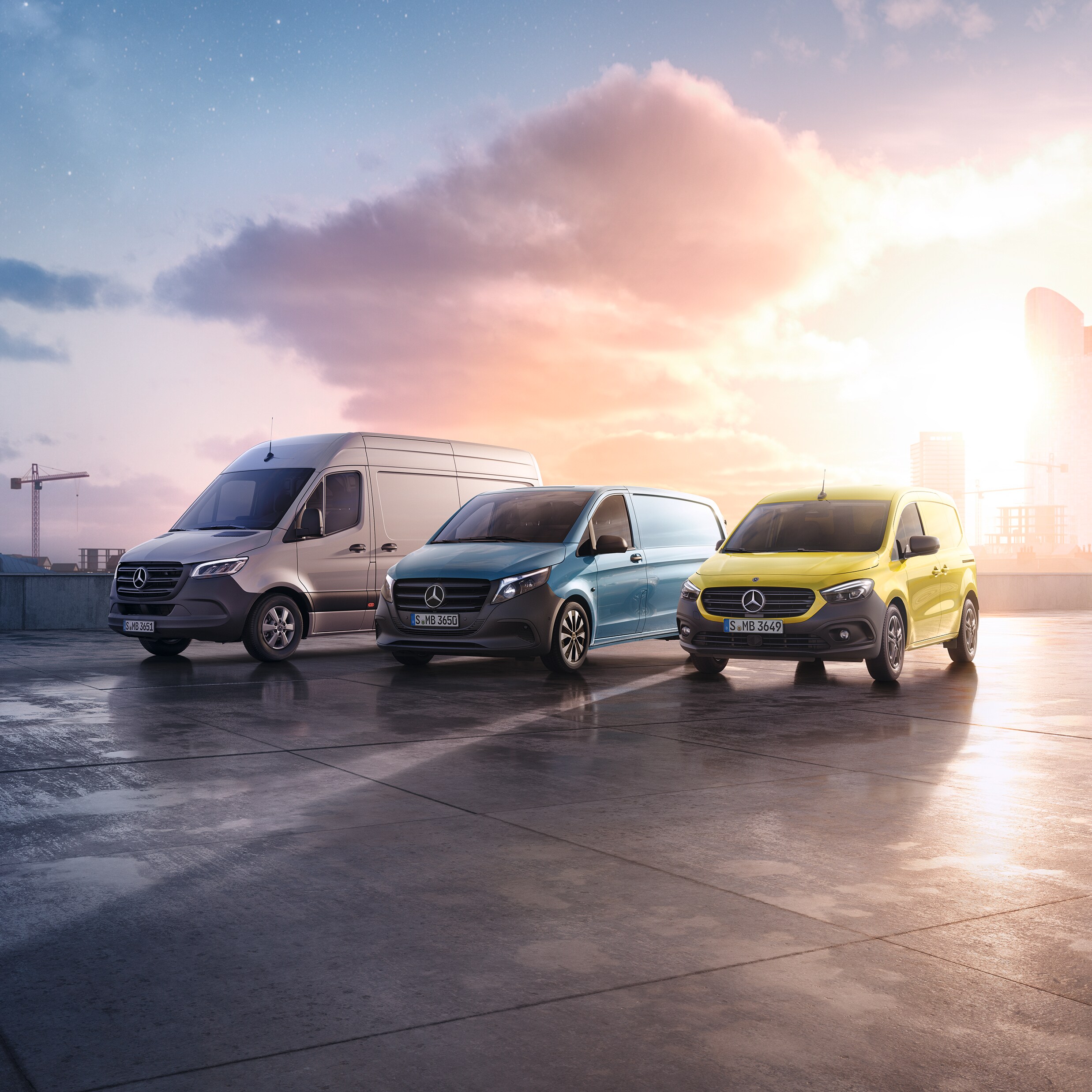 Drei Transportermodelle von Mercedes-Benz Transporter vor einer aufgehenden Sonne.