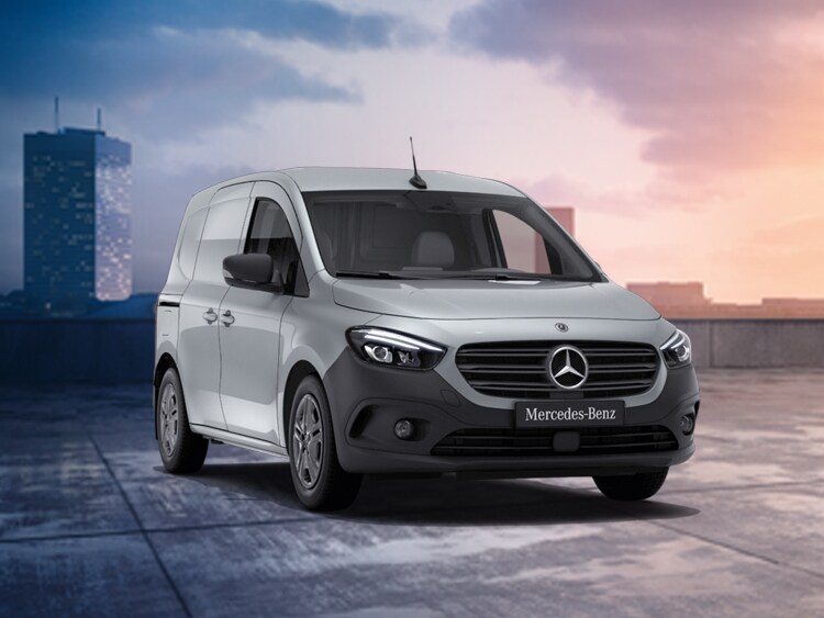 Ein silberner Citan von Mercedes-Benz auf einem Parkplatz vor einer untergehenden Sonne.