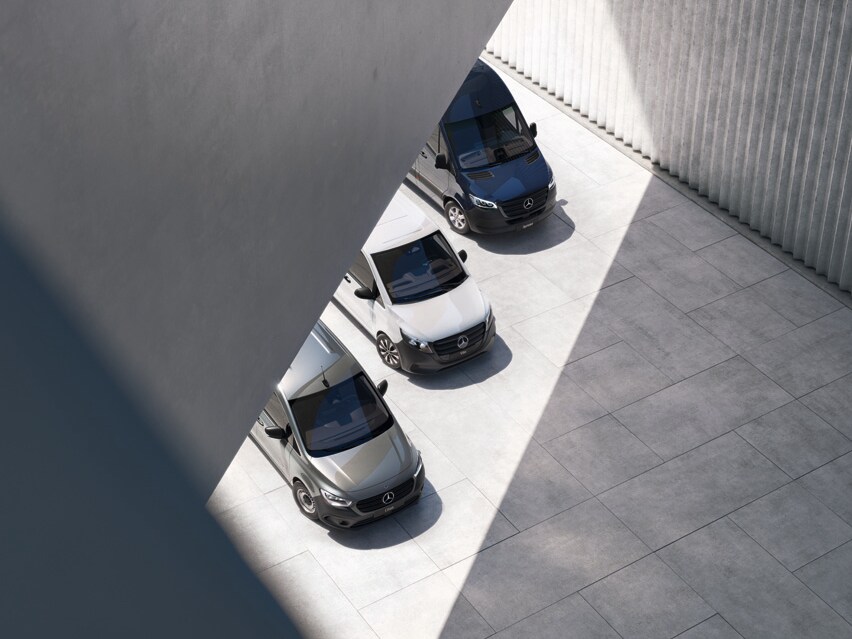 Drei Transportermodelle von Mercedes-Benz aus der Vogelperspektive auf Betongrund.