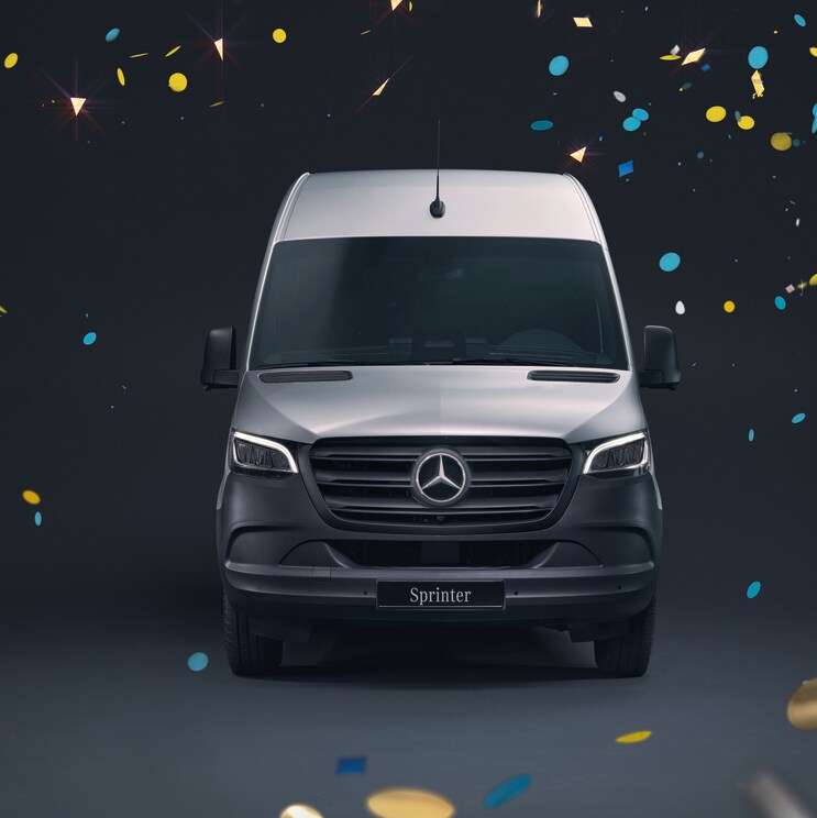 Ein Mercedes-Benz Sprinter in Frontalansicht vor einem schwarzen Hintergrund und fliegendem Konfetti herum.