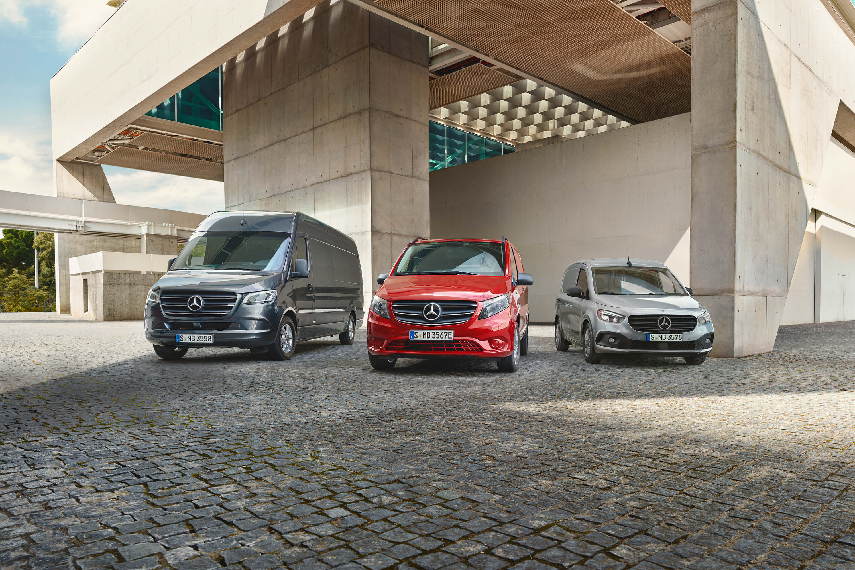 Flotten-Gebrauchtwagen-Center Drei Mercedes-Benz Transporter aus Frontansicht stehen unter einer Beton Brücke.