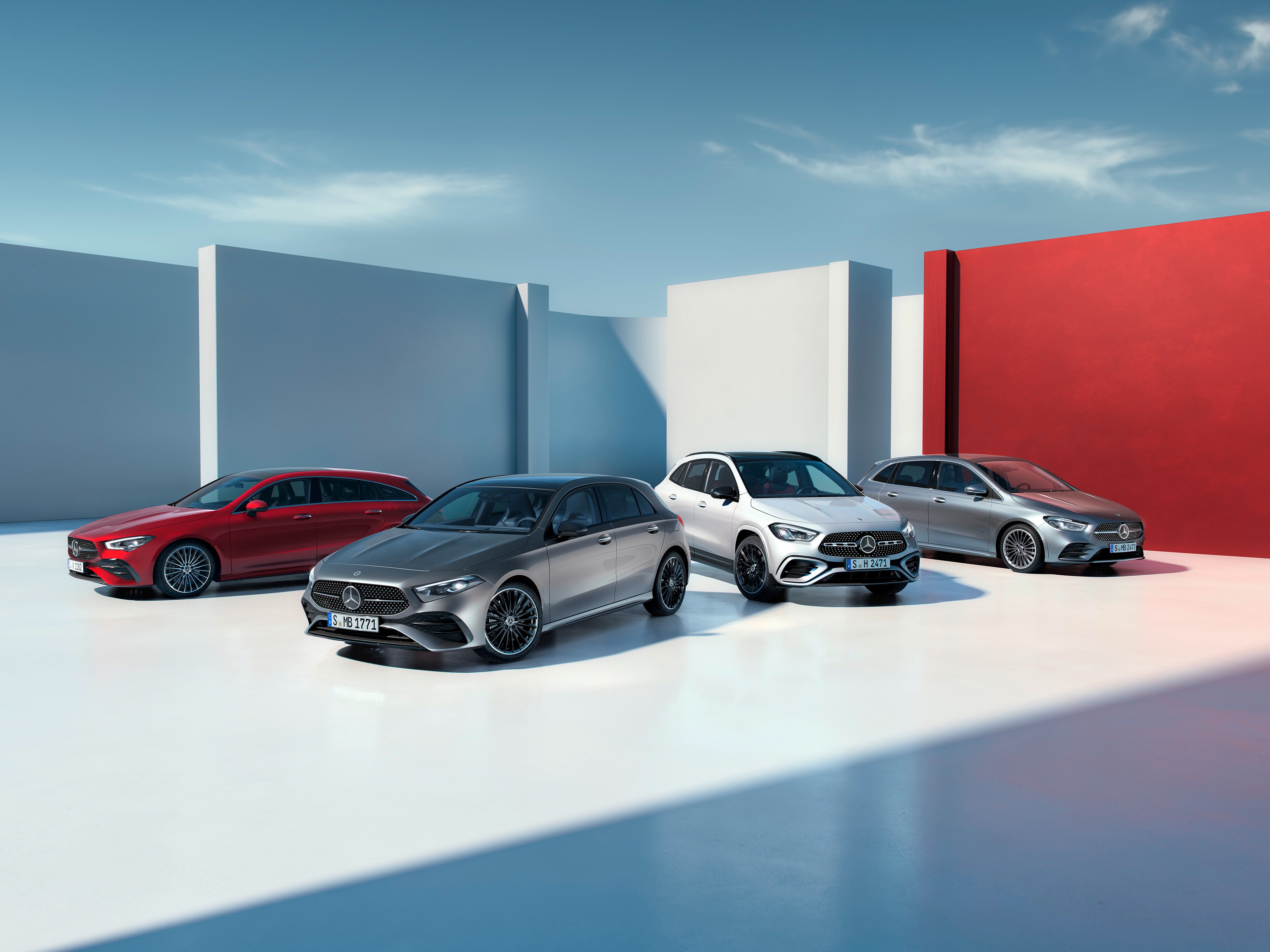 Drei Mercedes-Benz Fahrzeuge nebeneinander auf einer Straße in einer städtischen Umgebung.