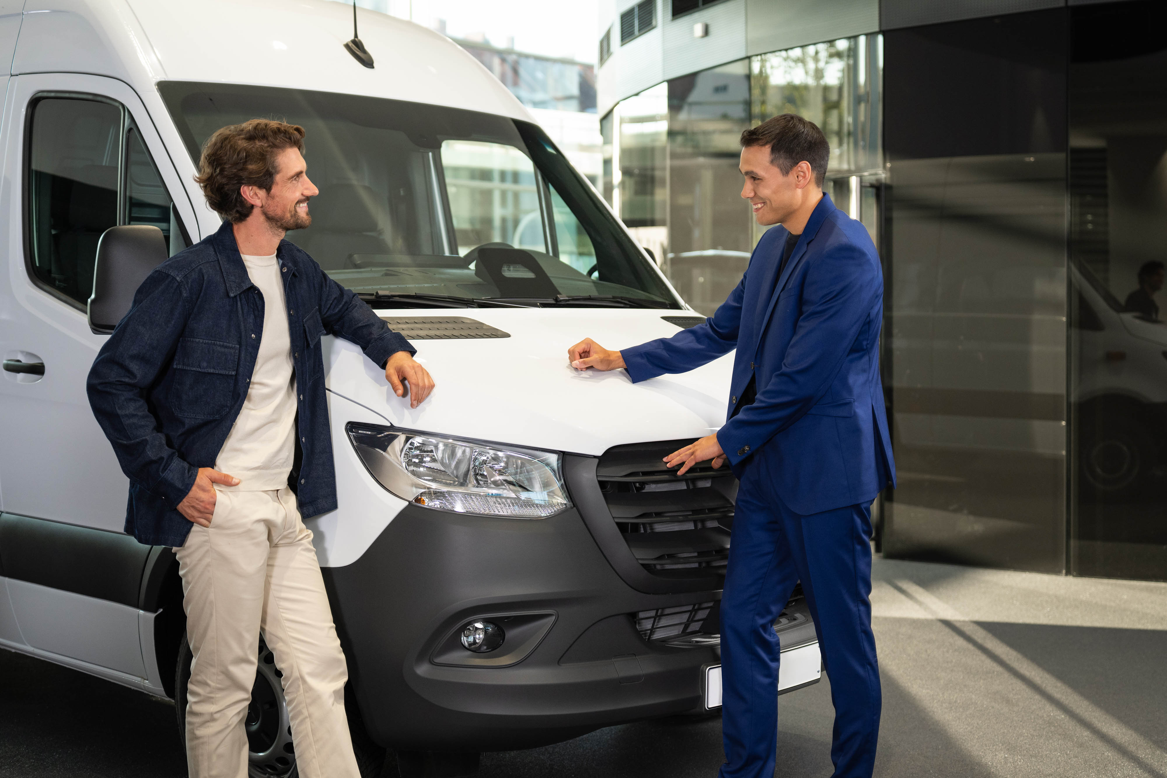 Mercedes-Benz Transporter Kontakt Zwei Personen lächeln und unterhalten sich vor einem Mercedes-Benz Transporter.