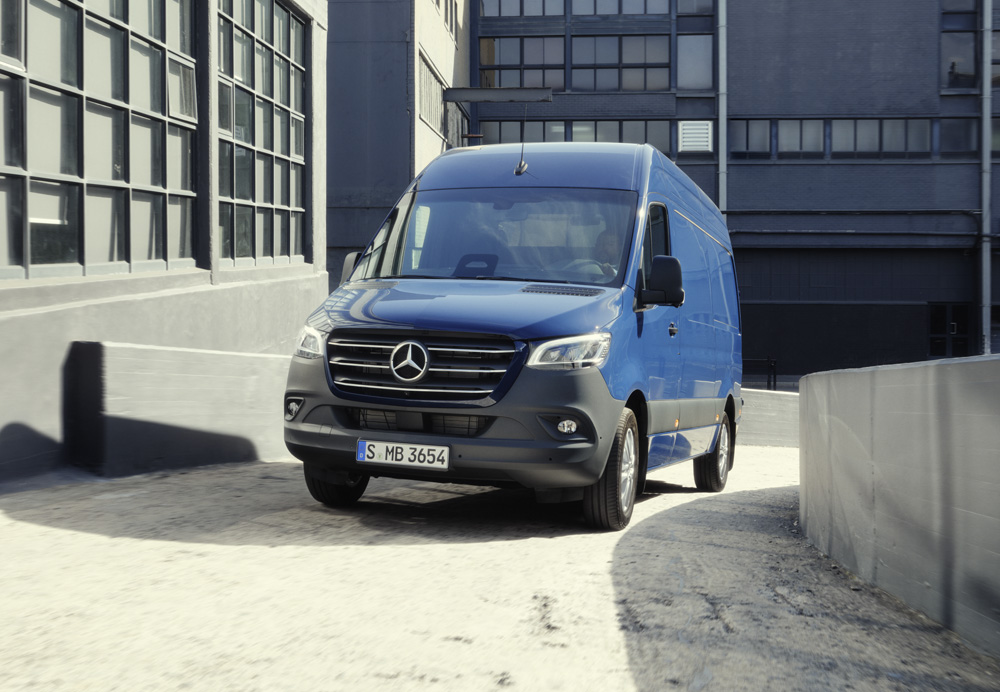 Leasingangebote | Mercedes-Benz Transporter. Ein blauer Sprinter Kastenwagen auf einer sonnigen Straße.