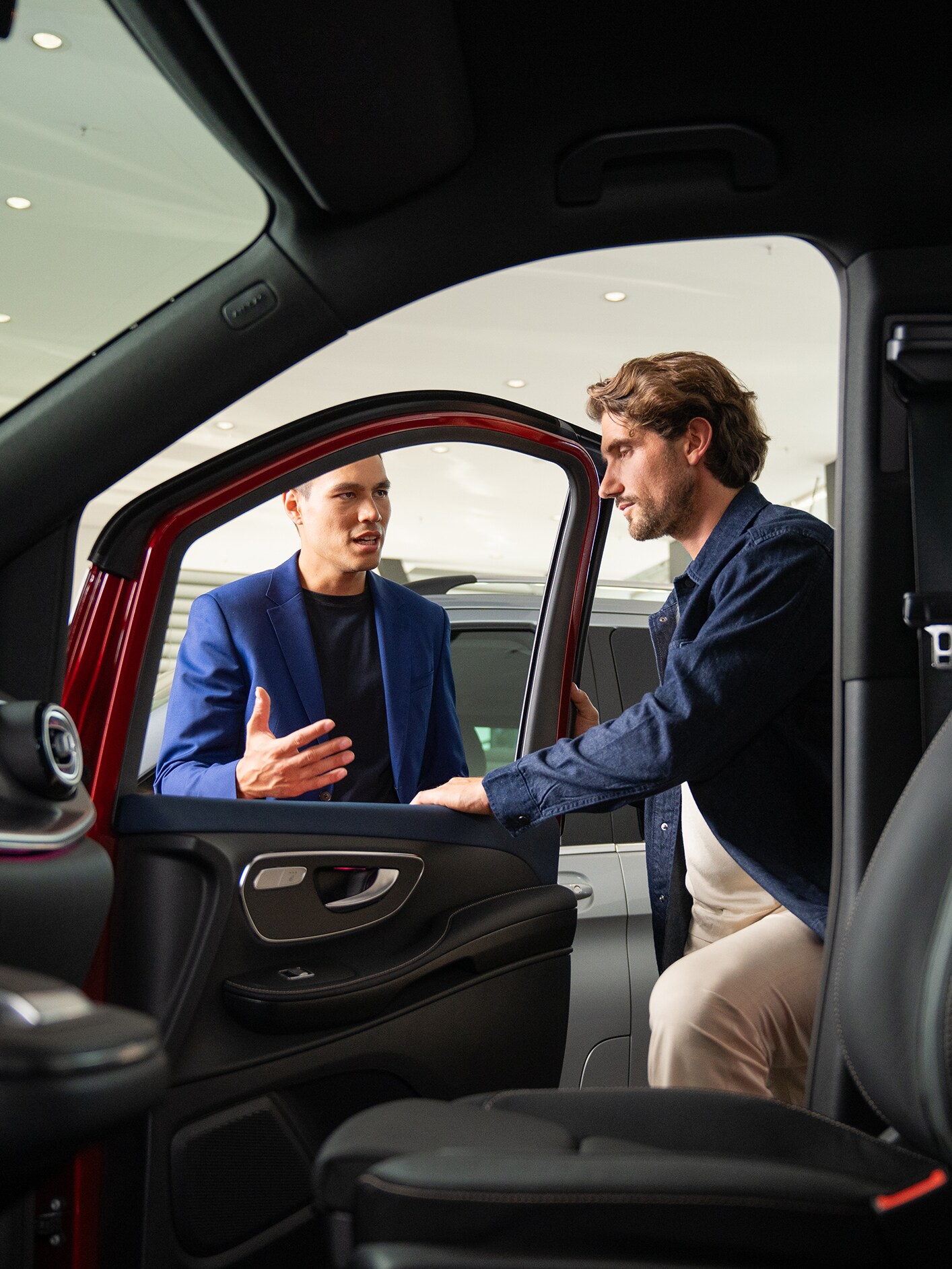 Innenansicht eines Mercedes-Benz Transporters mit Blick auf zwei sich unterhaltenden Personen an der geöffneten Tür.