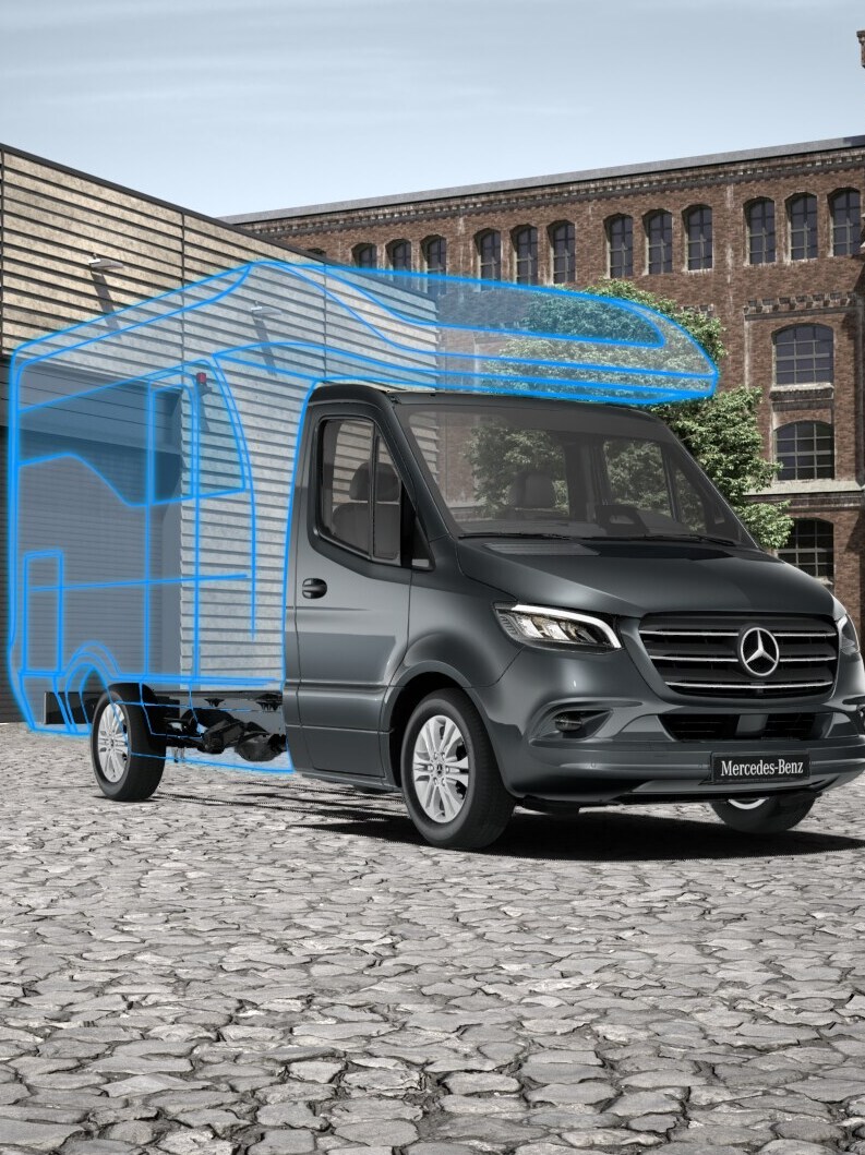 Ein Sprinter Fahrgestell als Basis mit einem gezeichneten Reisemobil Aufbau steht in einer Fabrikhalle.