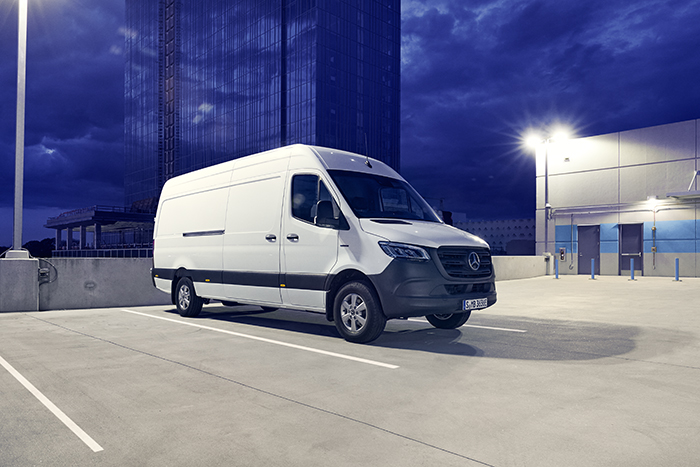 Mercedes-Benz | Tafel-Sponsoring Ein eSprinter Kastenwagen parkt vor einem blauen Hochaus.