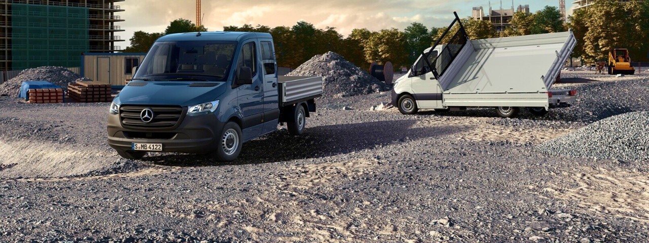 Highlights | Sprinter Pritschenfahrzeug | Mercedes-Benz Transporter Das Sprinter Pritschenfahrzeug auf einer Baustelle mit Schotterboden und einem Schuttberg im Hintergrund.