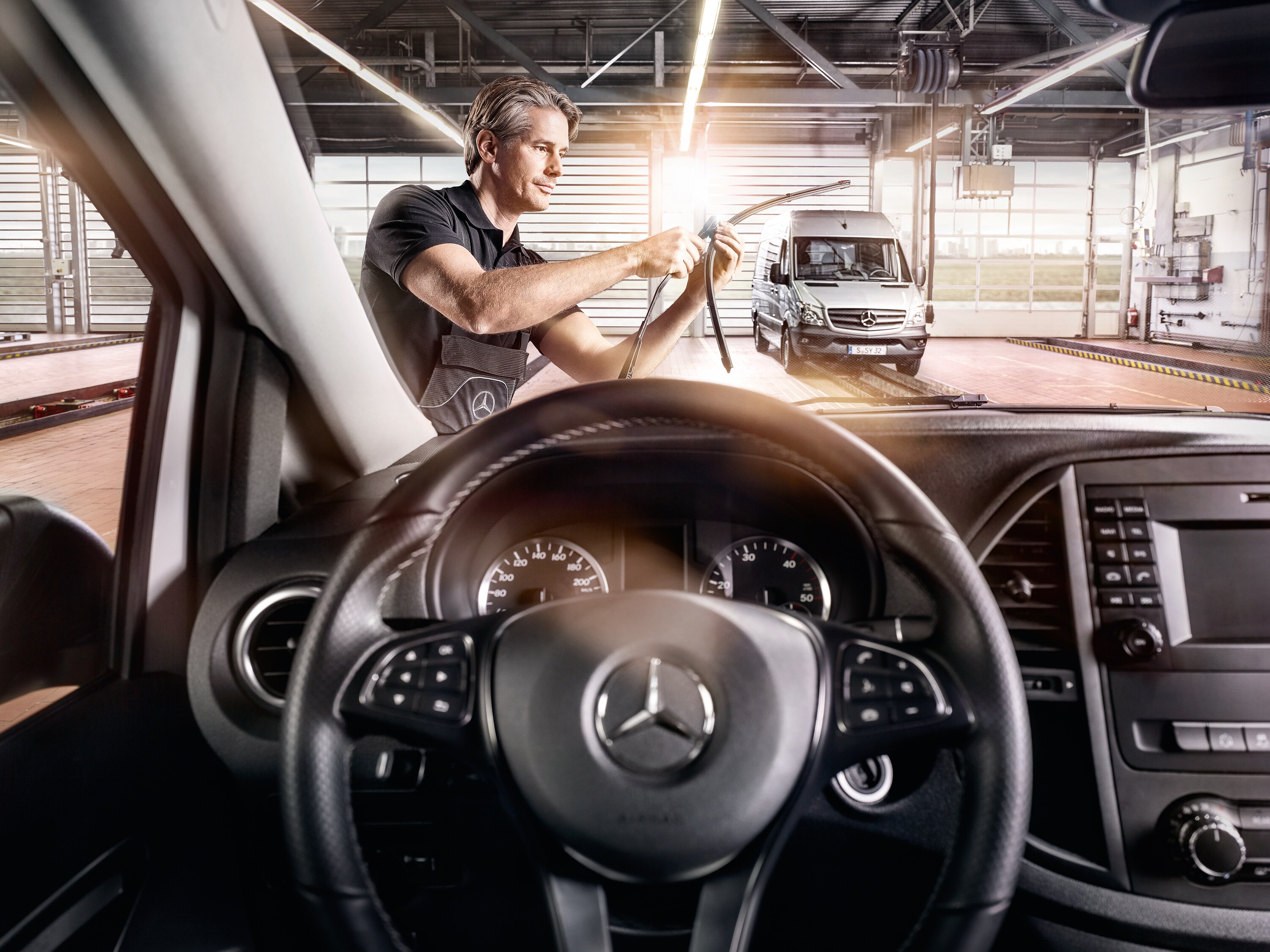 Ein Mercedes-Benz Service Mitarbeiter bei der Erneuerung von Wischerblätter.