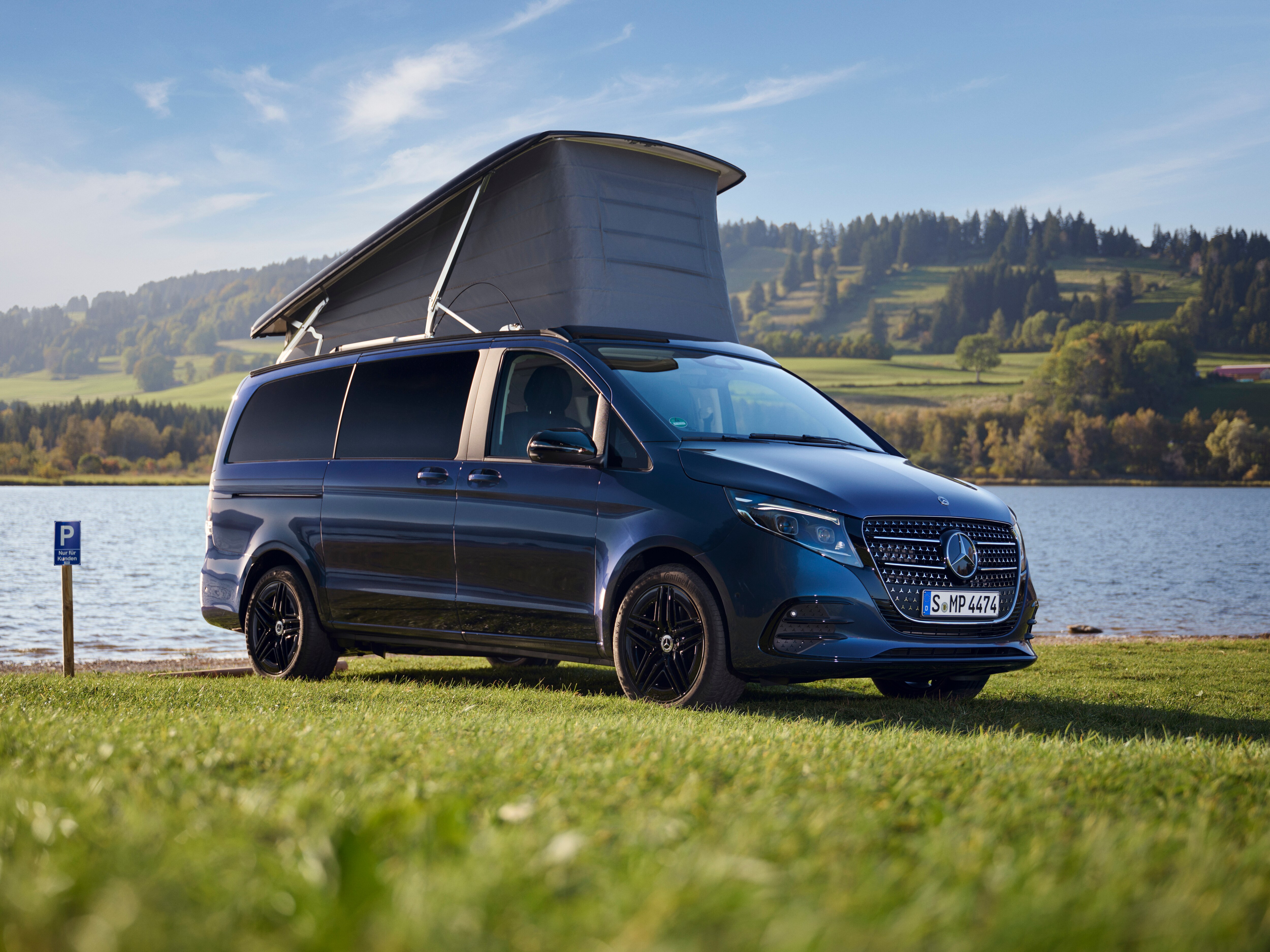 V-Klasse Marco Polo in Seitenansicht und aufgeklappten Dachbett, auf einem idyllischen Hintergrund am Fluss.