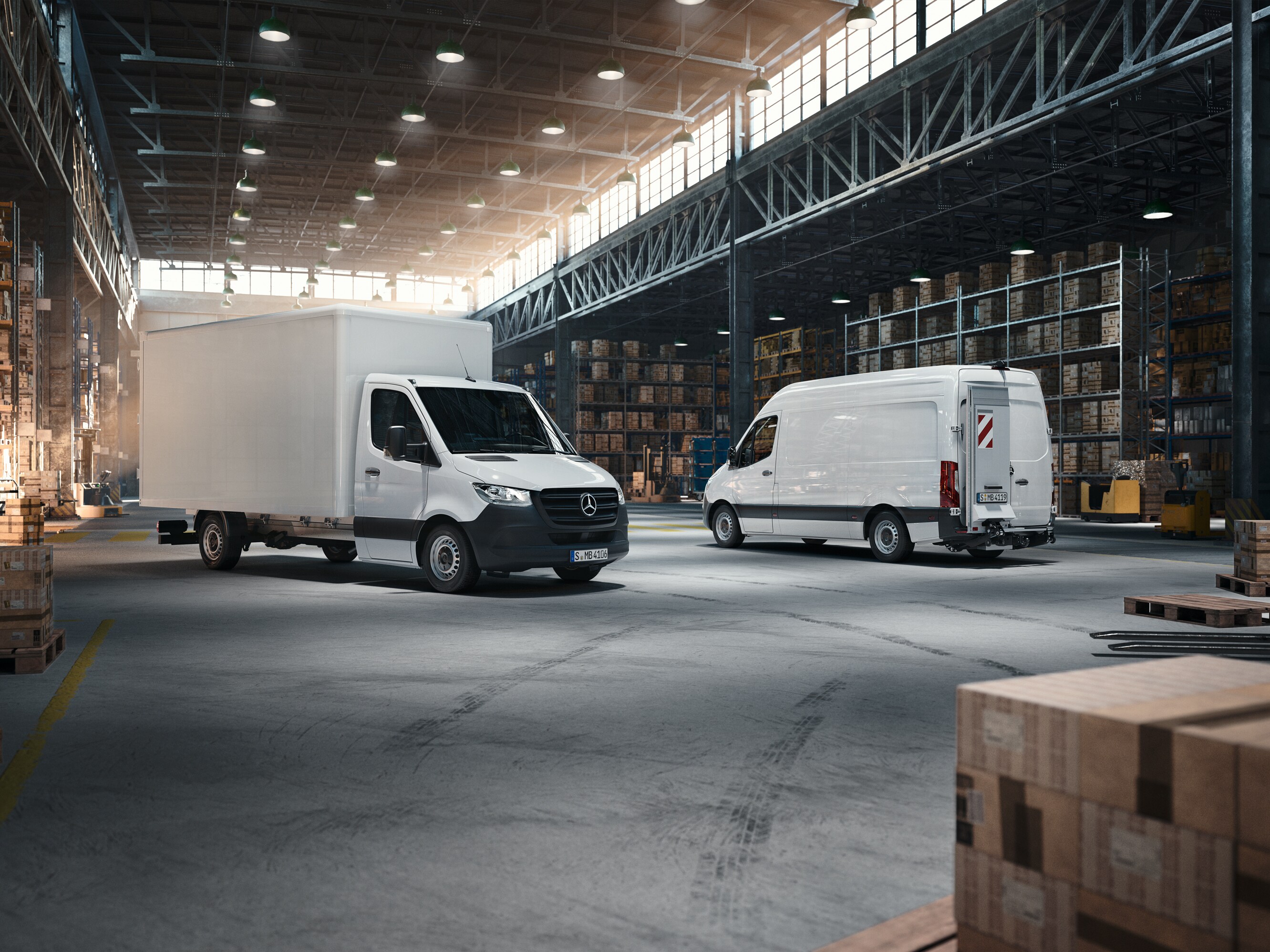 Zwei Vans von Mercedes-Benz stehen in einer Lagerhalle.