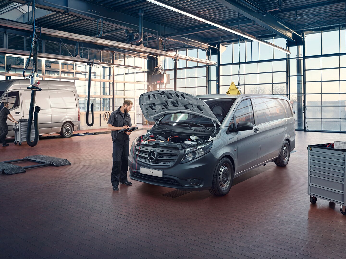 Ein Van steht mit offener Motorhaube in einer Werkstatt.