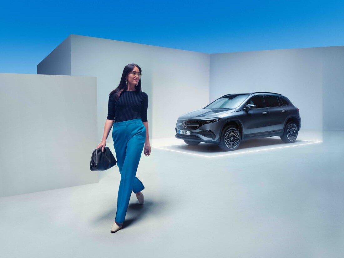 Eine Frau geht von ihrem geparkten Mercedes-Benz weg.