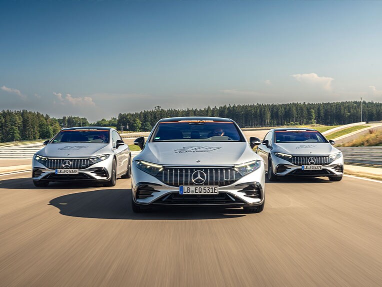 Drei Mercedes-AMG Modelle auf einer Rennstrecke.
