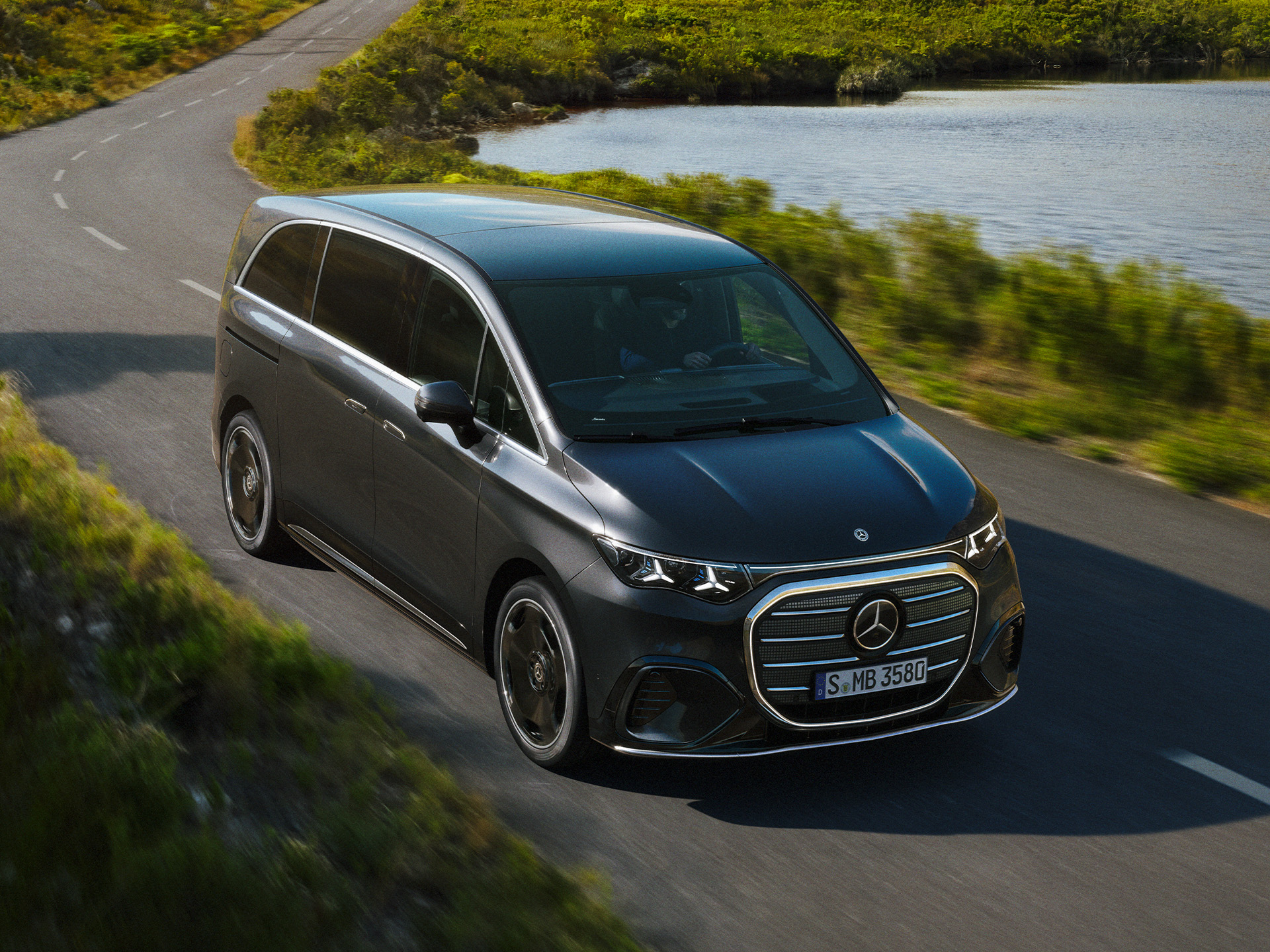 Grand Limousinen | 7-Sitzer Pkw & Vans | Mercedes-Benz Der Mercedes-Benz VLE auf einer kurvenreichen Straße in der Nähe eines Sees.
