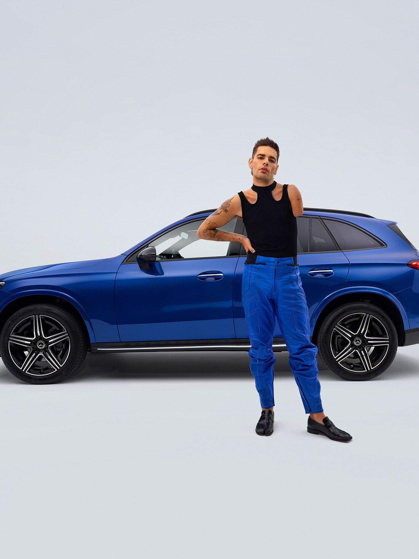 Seitenansicht eines umgebauten Mercedes-Benz GLC SUV für Behinderte und im Vordergrund ein Mann mit einer Armamputation.