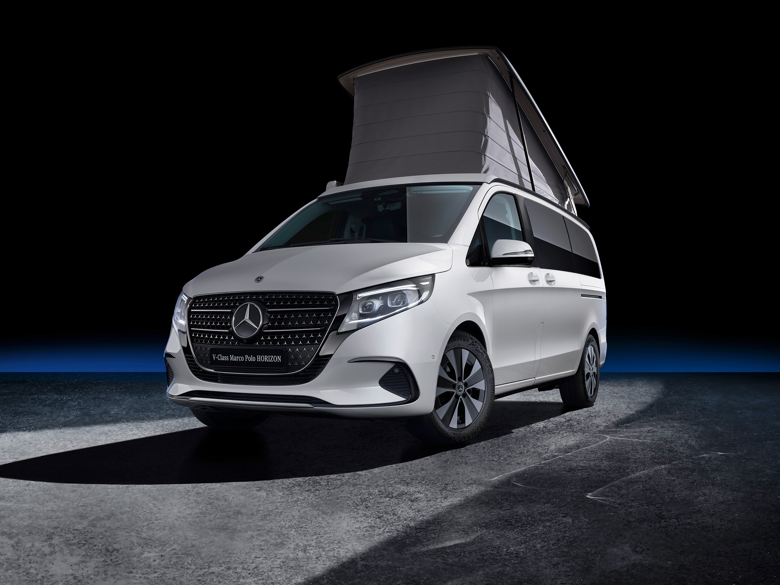 Ein Marco Polo HORIZON mit Aufstelldach inmitten einer eines schwarzen Hintergrundes.