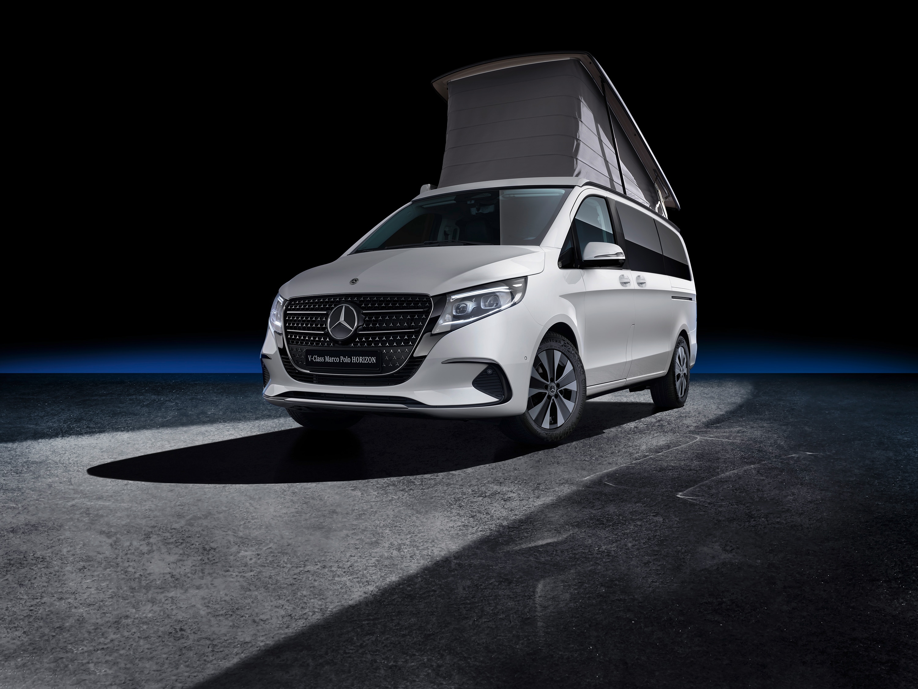 Sprinter Wohn- & Reisemobile | Mercedes-Benz Ein Marco Polo HORIZON mit Aufstelldach inmitten einer eines schwarzen Hintergrundes.