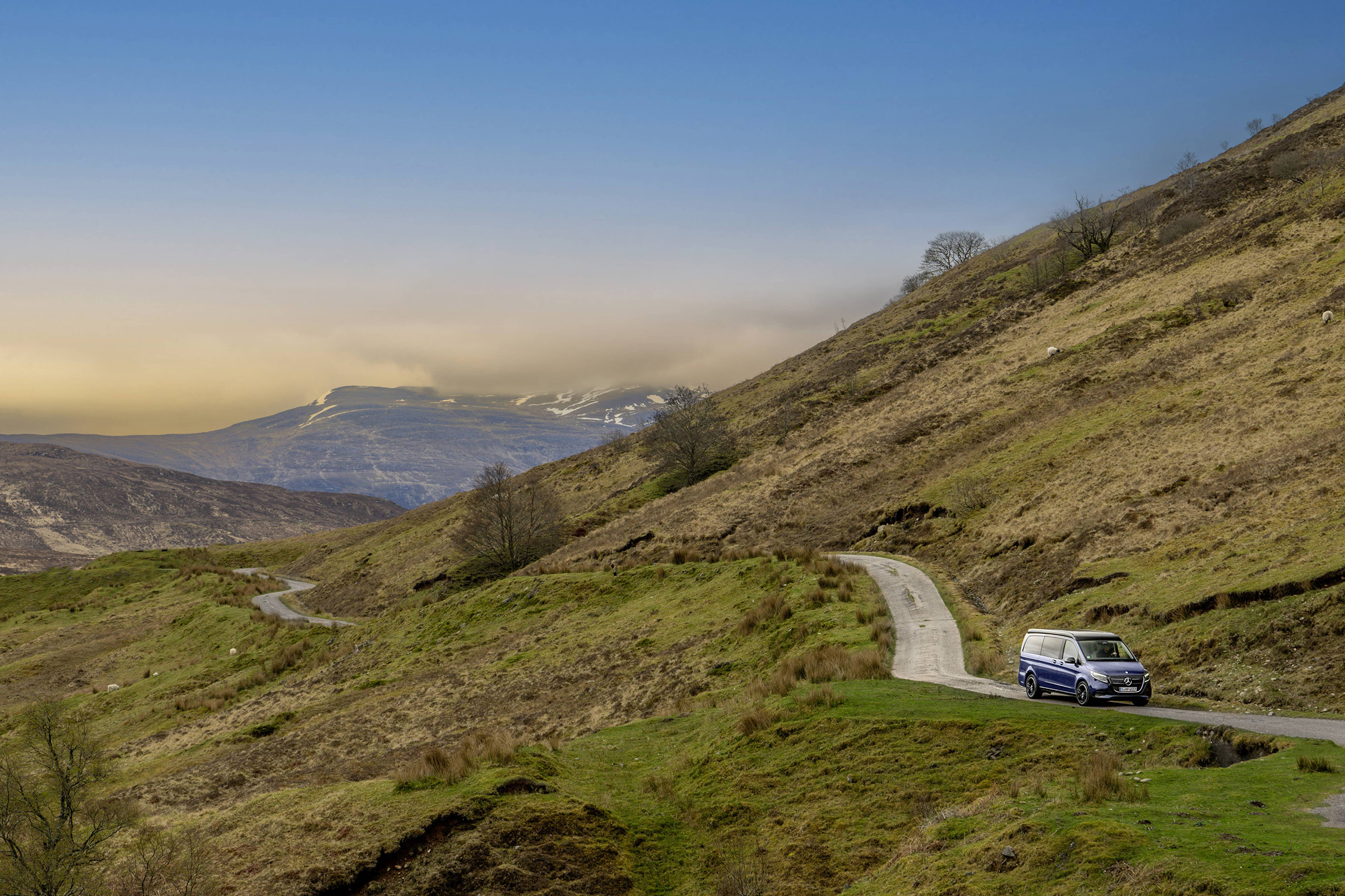 Camping-Welt | Mercedes-Benz Ein dunkelblauer Mercedes-Benz Marco Polo unterwegs auf malerischen Bergstraßen.