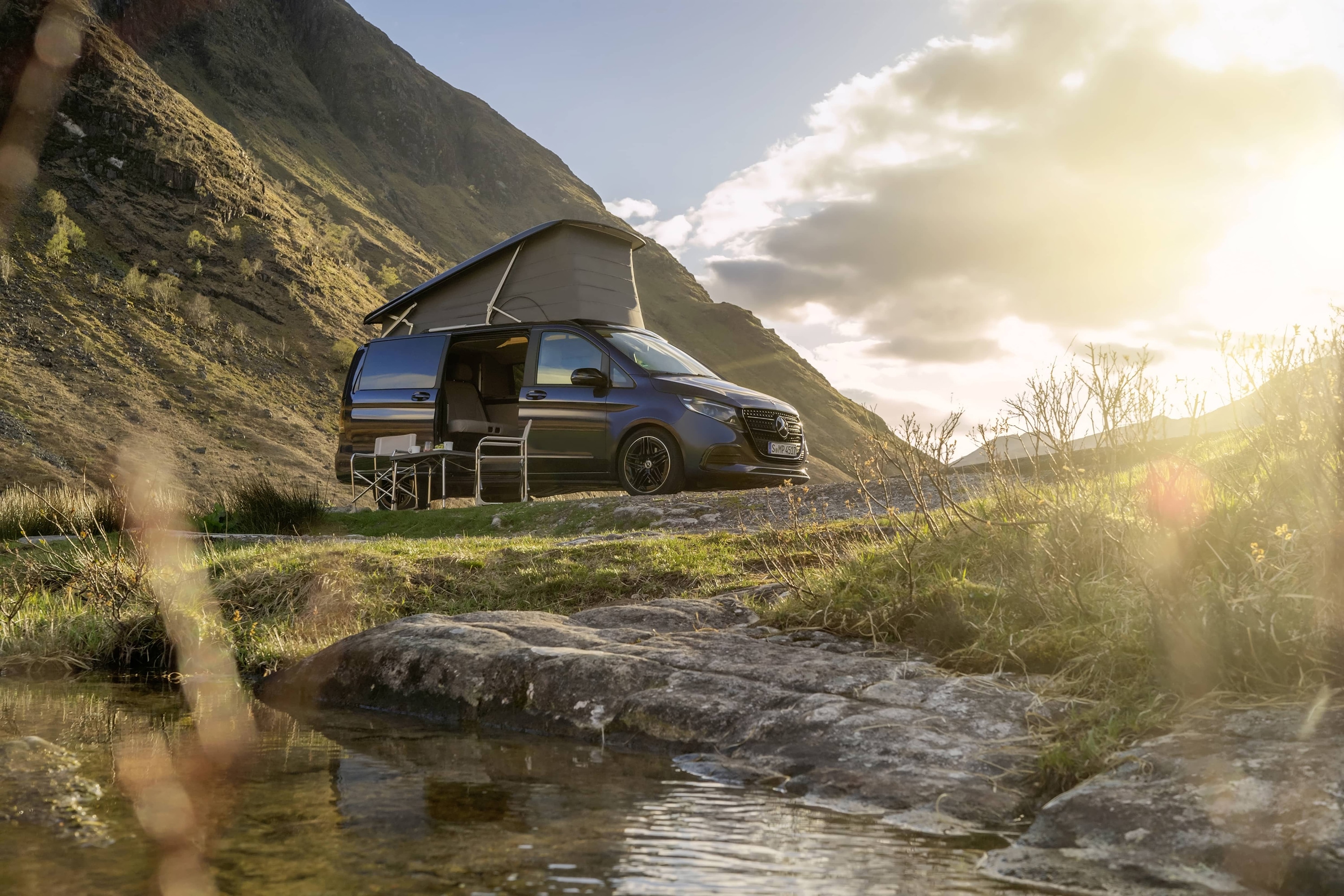 Sprinter Wohn- & Reisemobile | Mercedes-Benz Ein Mercedes-Benz Marco Polo-Wohnmobil mit Aufstelldach inmitten einer malerischen Berglandschaft.