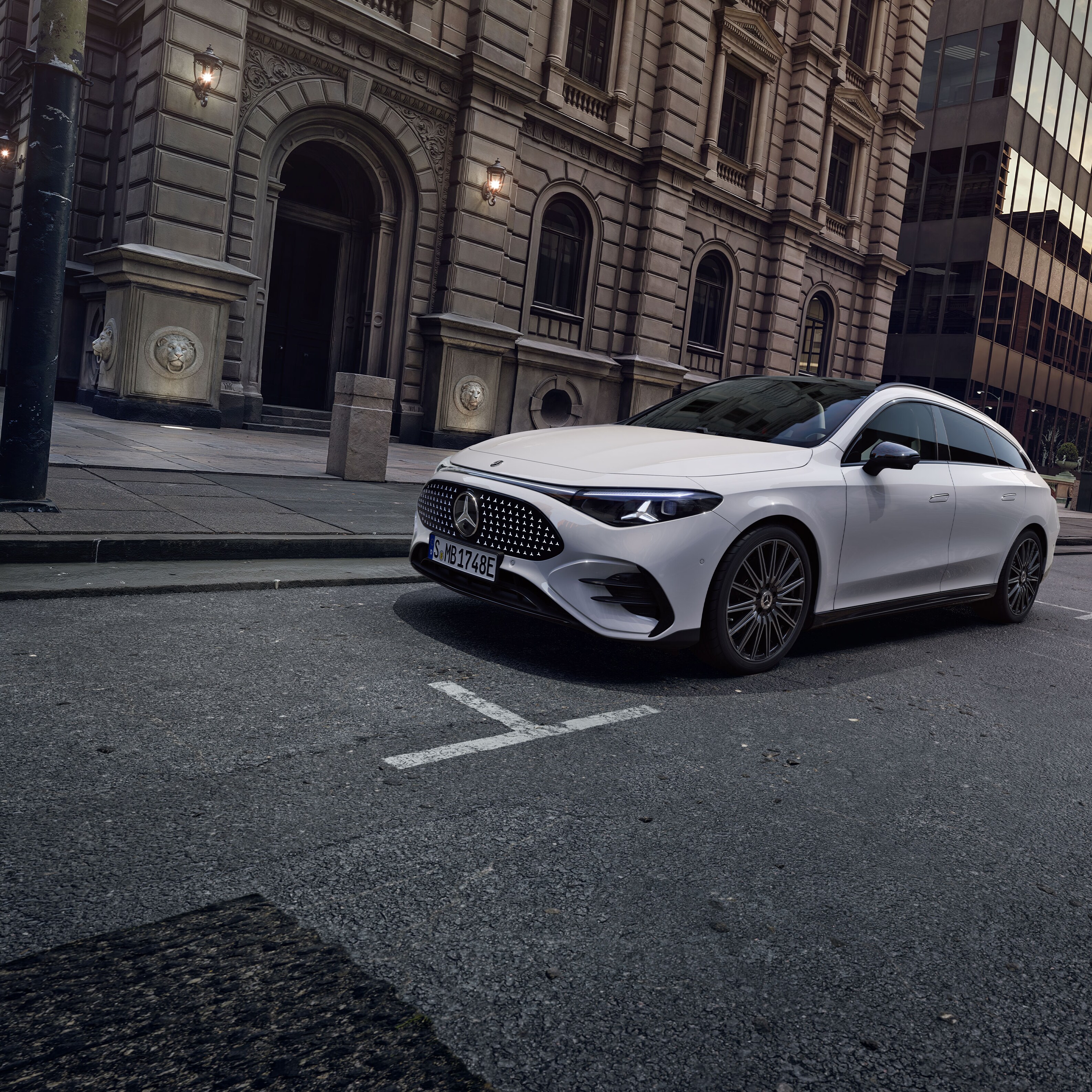 Ein weißer, vollelektrischer CLA Shooting Brake vor einer detailreichen Fassade.