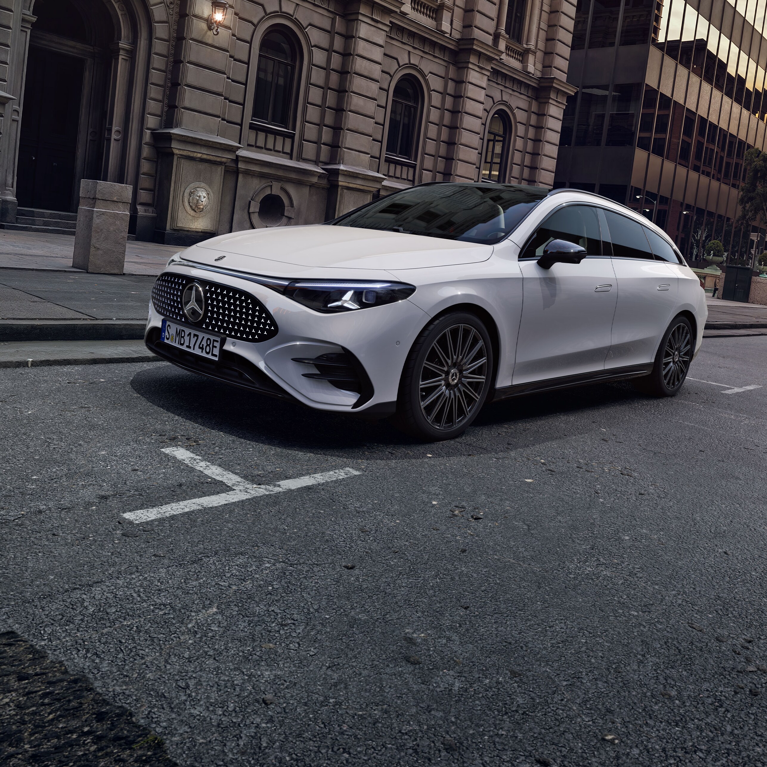 Ein weißer, vollelektrischer CLA Shooting Brake vor einer detailreichen Fassade.