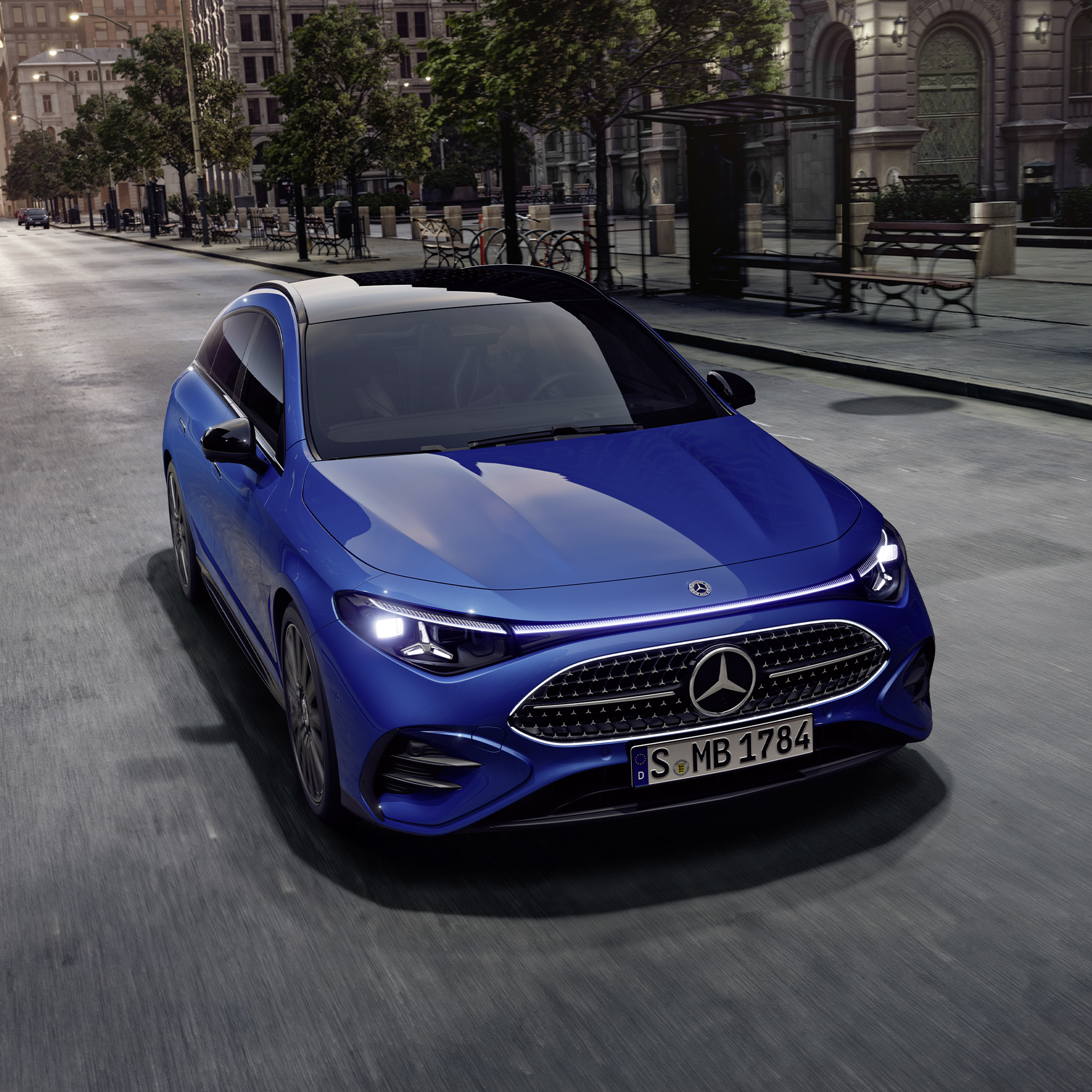 CLA Shooting Brake | Mercedes-Benz. Ein strahlend blauer CLA Shooting Brake mit leuchtenden Scheinwerfern auf einer grauen Straße.