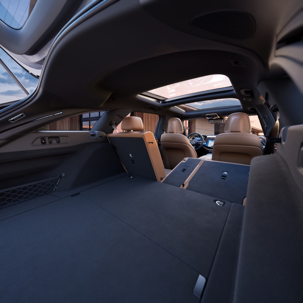 Ein Blick von hinten in das flexible innere Raumkonzept der E-Klasse von Mercedes-Benz  bei heruntergeklappten Fondlehnen.