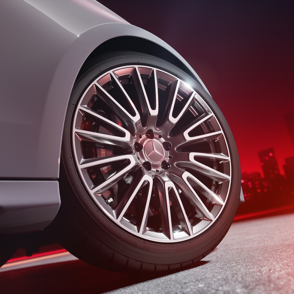 Detailaufnahme eines AMG Schmiederads mit AMG Hochleistungs-Verbundbremsanlage mit rot lackierten Bremssätteln.
