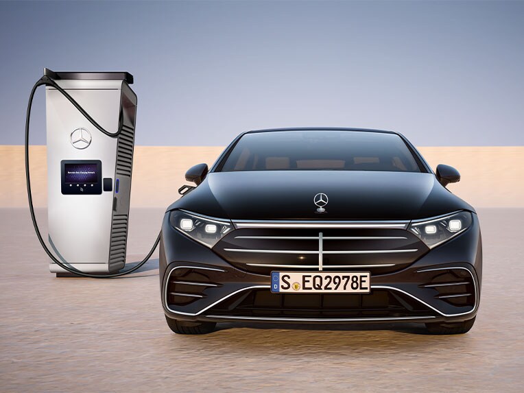 Die EQS Limousine von Mercedes-Benz in der Frontansicht beim Laden an einer öffentlichen Ladestation.