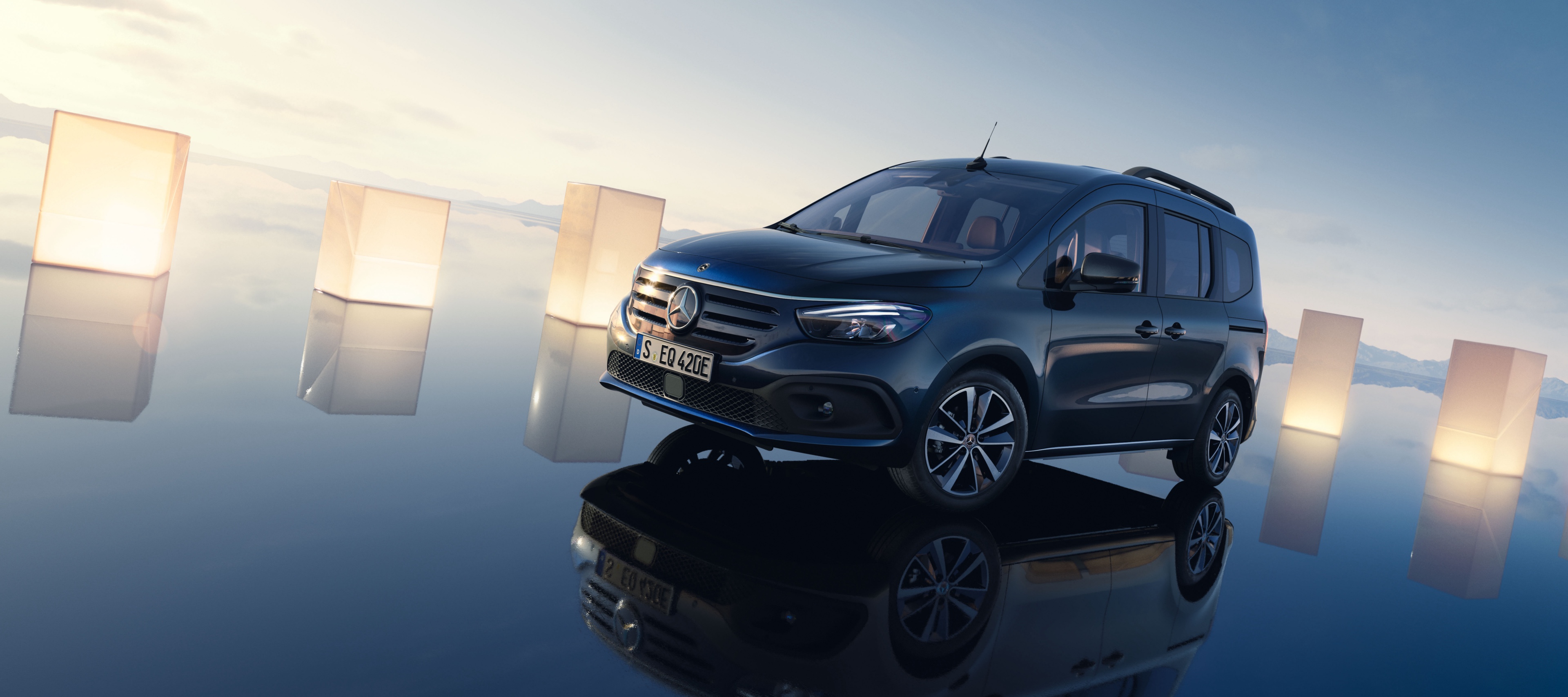 EQT | Discontinued | Mercedes-Benz. Ein dunkelblauer EQT auf einer spiegelnden, blauen Oberfläche umringt von Papierlaternen.