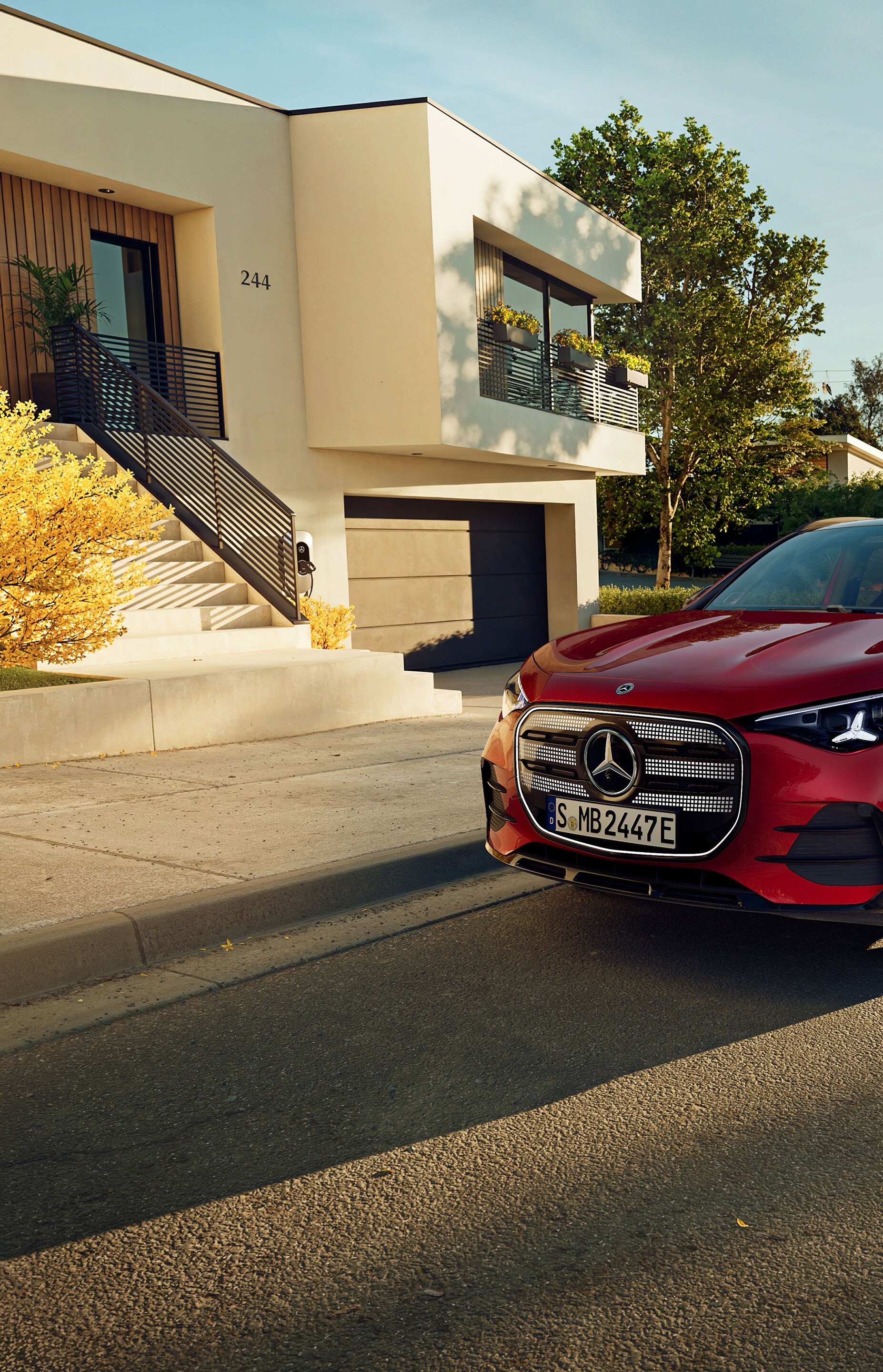 Der brandneue elektrische GLA von Mercedes-Benz parkt auf einem Parkplatz neben einem Café.