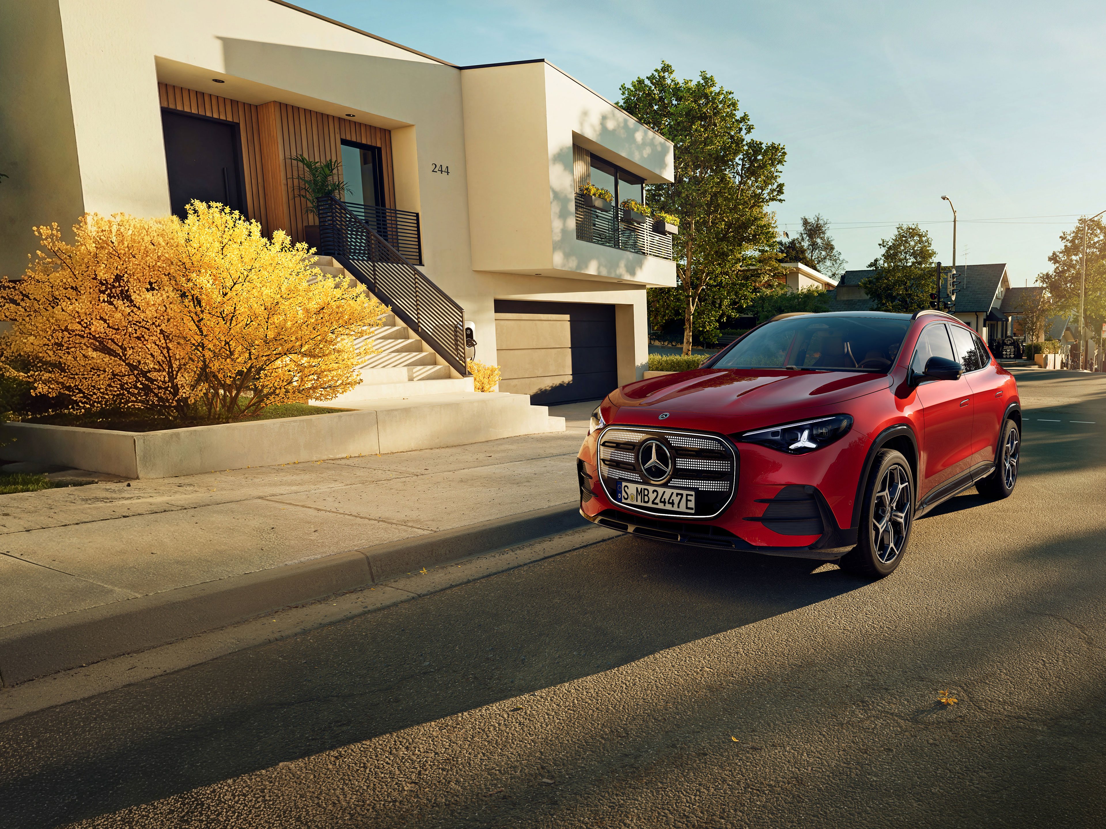 Exterieur | Der brandneue elektrische GLA | Mercedes-Benz Der brandneue elektrische GLA von Mercedes-Benz parkt auf einem Parkplatz neben einem Café.