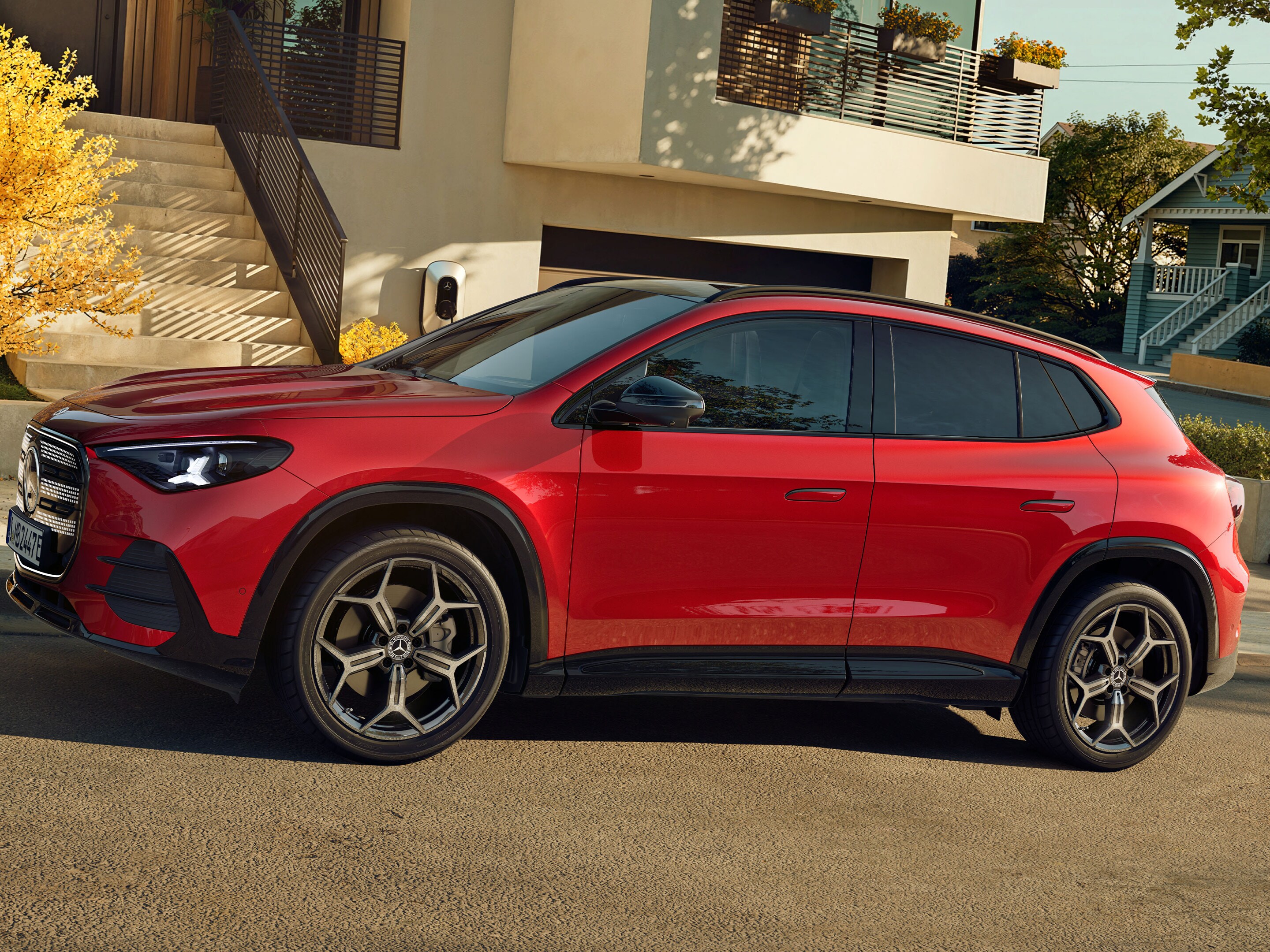 Der neue elektrische GLA stehend vor einem Haus.