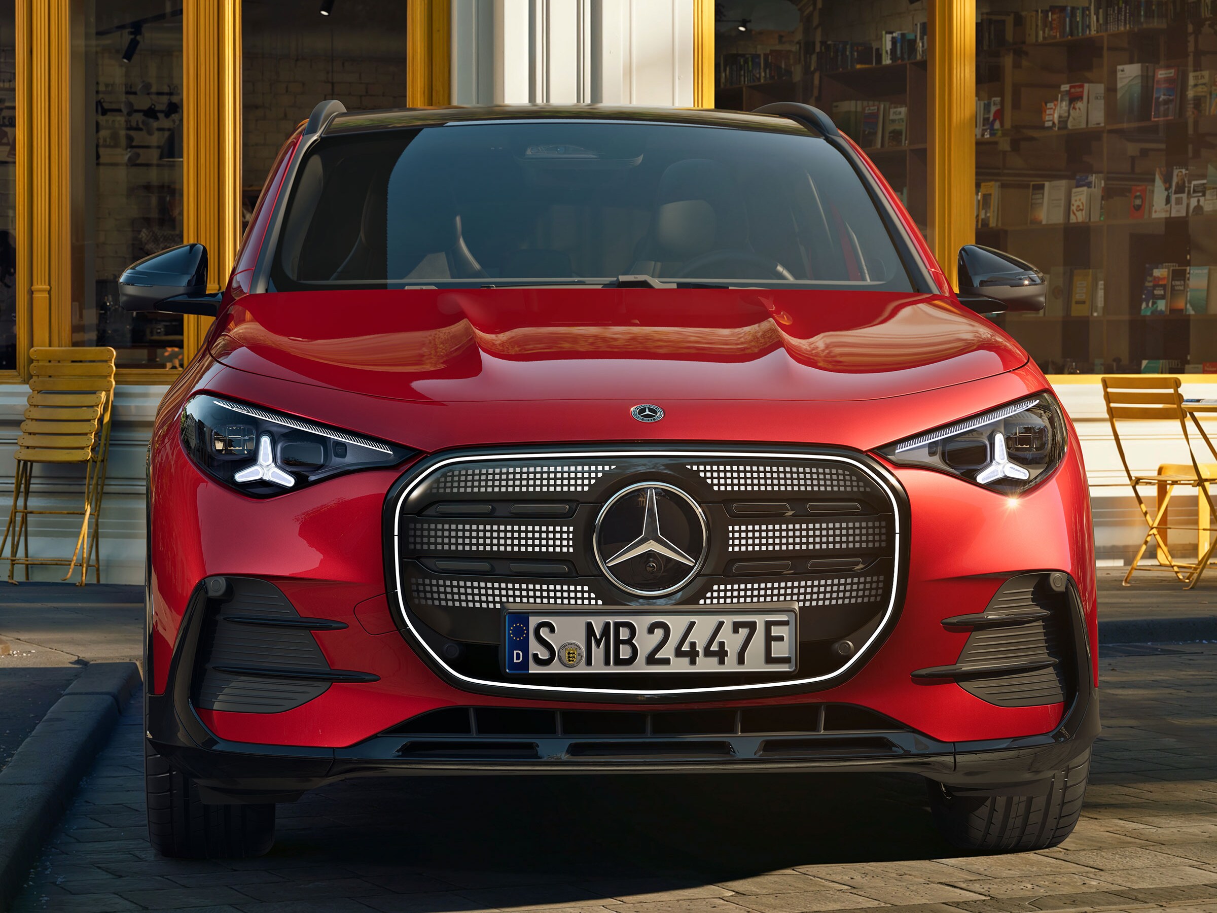 Der neue elektrische GLA in Rot in Frontalansicht steht auf einer Straße in einer Wohnsiedlung.