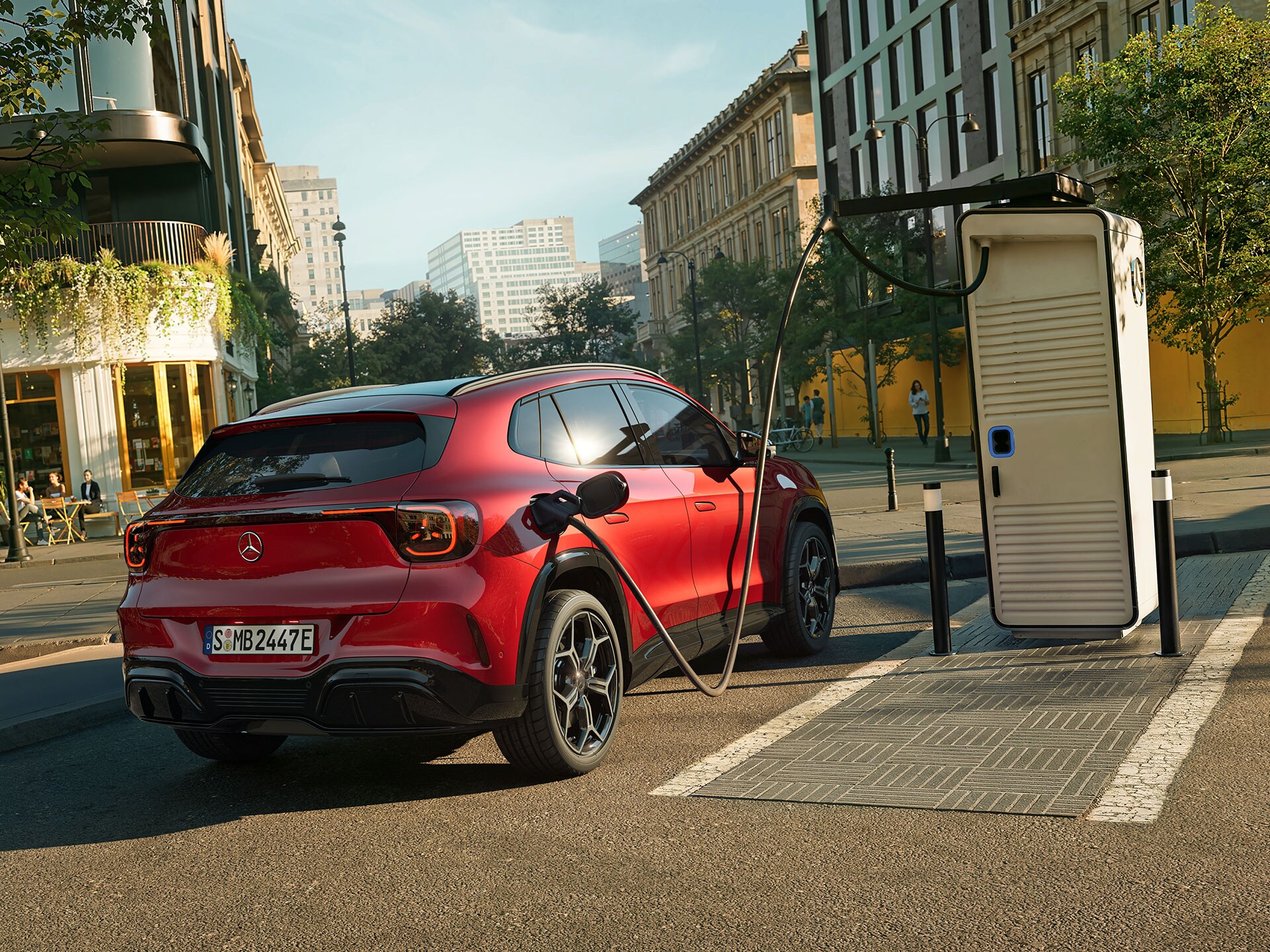 Der brandneue elektrische GLA von Mercedes-Benz steht während des Ladevorgangs neben einer Ladestation.