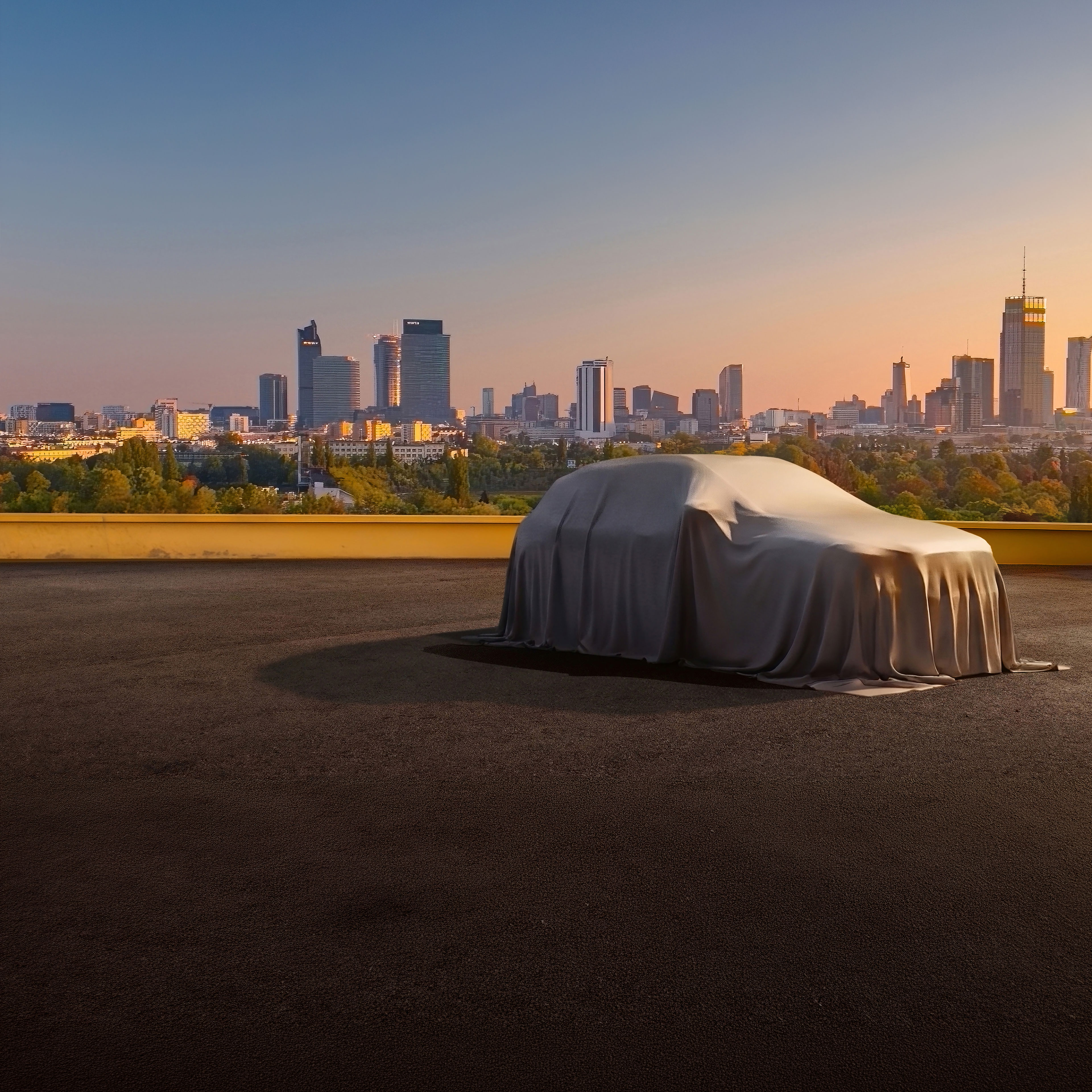 Mercedes-Benz | Deutschland - Offizielle Webseite Ein eingehülltes Mercedes-Benz Modell im Sonnenuntergang. Im Hintergrund ist eine Stadt.